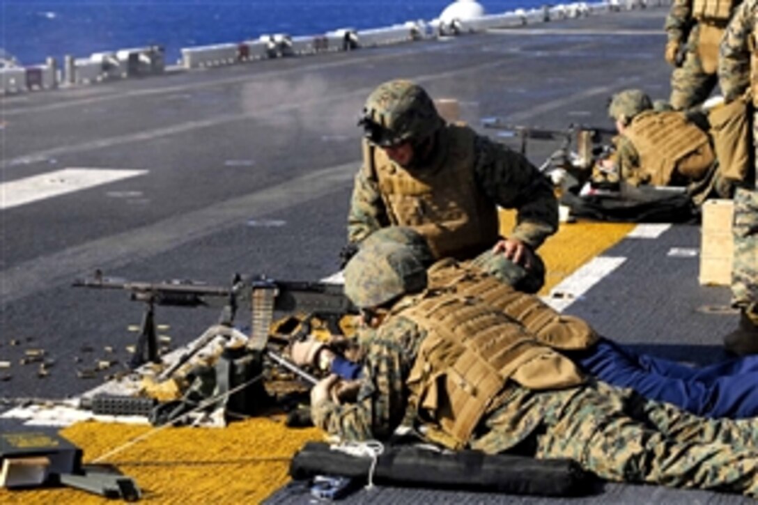 Chaplain (Lt.) Russel Martin, center, fires a 240-B automatic weapon during small weapons training on the flight deck of the amphibious assault ship USS Boxer in the Pacific Oean, Nov.  4, 2008. Boxer is conducting training exercises in the Pacific Ocean preparing for a deployment scheduled for early next year.