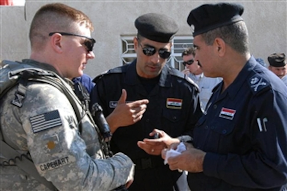 U.S. Army Maj. Stephen Capehart, left, speaks with members of the Iraqi National Police following the town hall opening ceremony in Mayssaibb, Iraq, Nov. 5, 2008. Capehart is assigned to the 3rd Infantry Division's 3rd Battalion, 7th Calvary Regiment.