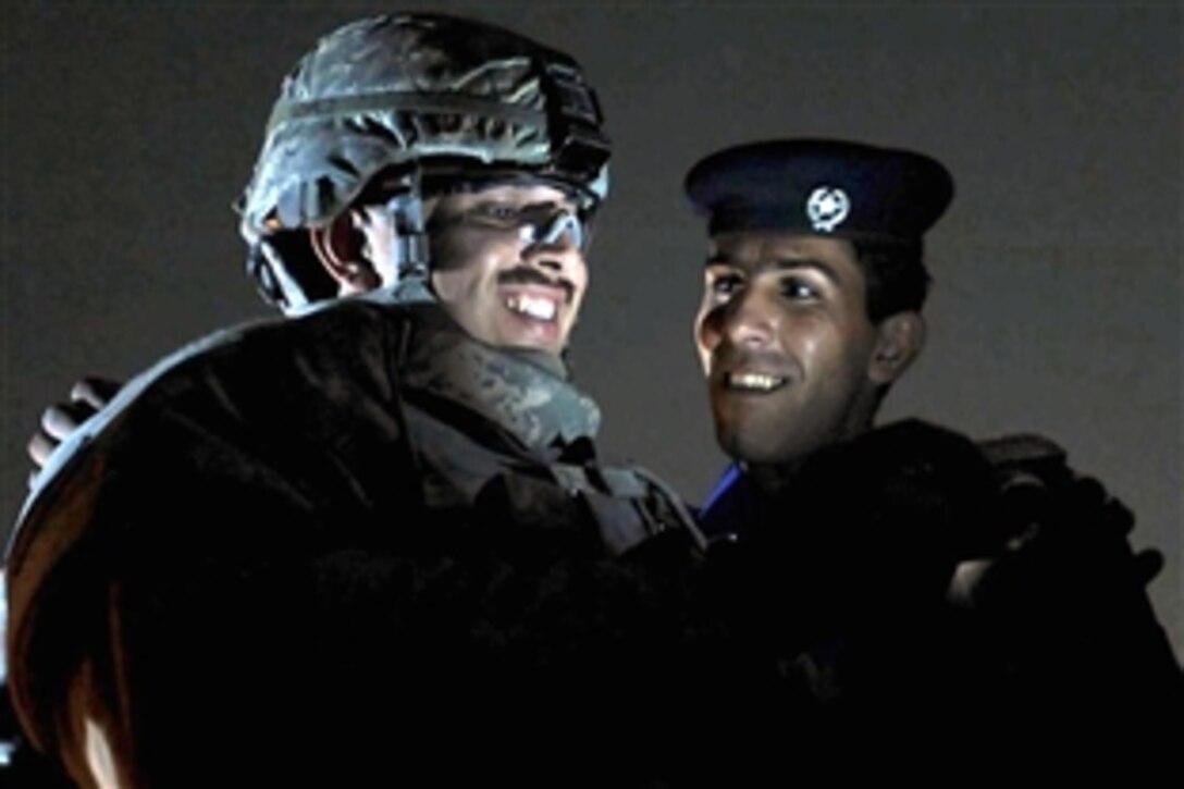 U.S. Air Force Senior Airman Brian Lopez, left, looks at a digital photo with an Iraqi National Police officer, near the Abu T'shir National Police Headquarters in southern Baghdad, Iraq, Nov. 4, 2008. Lopez is assigned to Detachment 3, 732nd Expeditionary Security Forces Squadron.