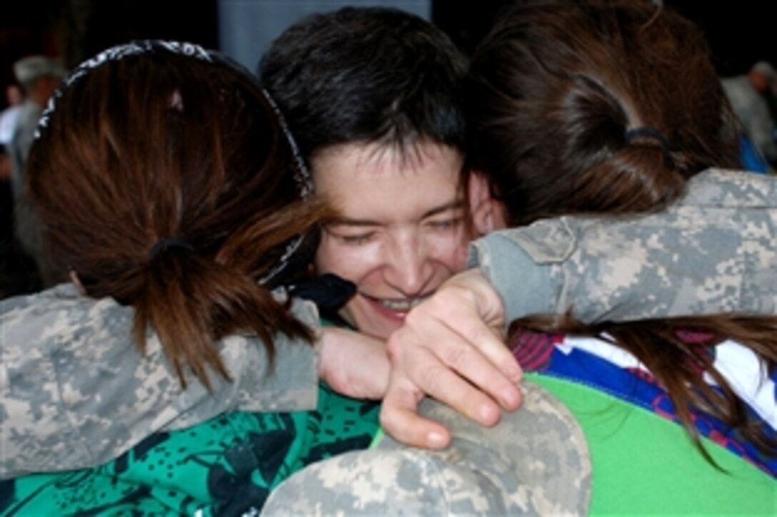 Army Chief Warrant Officer Nicole Carmody hugs her daughters, Kayleigh, left, and Justess, right, Nov. 5, 2008, upon her return from Iraq. Carmody is a military personnel technicial with the Indiana National Guard's Headquarters Company, 76th Infantry Brigade Combat Team. During the brigade's deployment, it supported security missions, aerial reconnaissance missions, presence patrols, convoy escorts, and high profile reconstruction efforts to the Iraqi economy. 