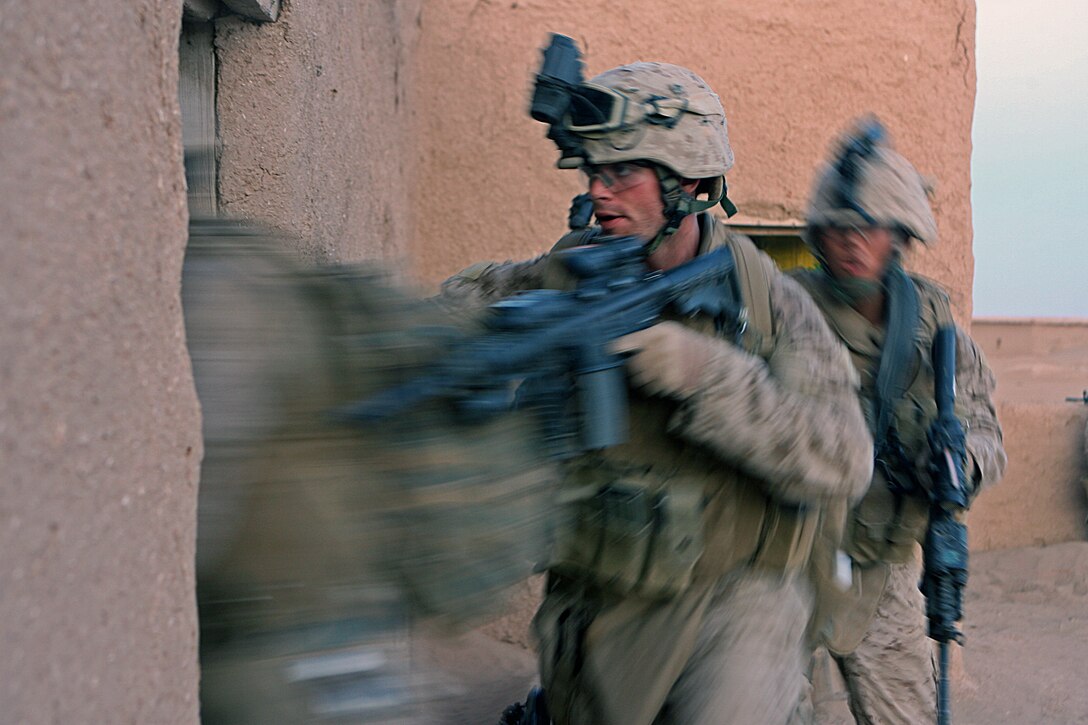 Lance Cpl. Kendall R. Strop, team leader, Military Police detachment, 1st Marine Logistics Group, storms into a building with fellow Marines here Nov. 9. The Marines of the Military Police detachment here completed their first security and reconnaissance patrol in Iraq’s northern Nineweh Province Nov. 9. Strop, 21, Klamath Falls, Ore., and the MPs here shoulder the task of base security here, which includes presence patrols through adjacent towns and abandoned structures. Their mission Nov. 9 was to clear out and secure an old, abandoned town located just a kilometer west of Camp Sinjar. As insurgent activity continues in Mosul, a city located East of Sinjar, Marine presence in smuggler jump off points and safe havens serves to choke off possible enemy supply routes. The MPs are just one part of the first Marine Air Ground Task Force outside Anbar in Iraq since 2004. They traveled to the Nineweh province to kick off Operation Defeat Al Qaeda in the North II, an operation aimed at stamping out the insurgency just west of the restive city of Mosul.