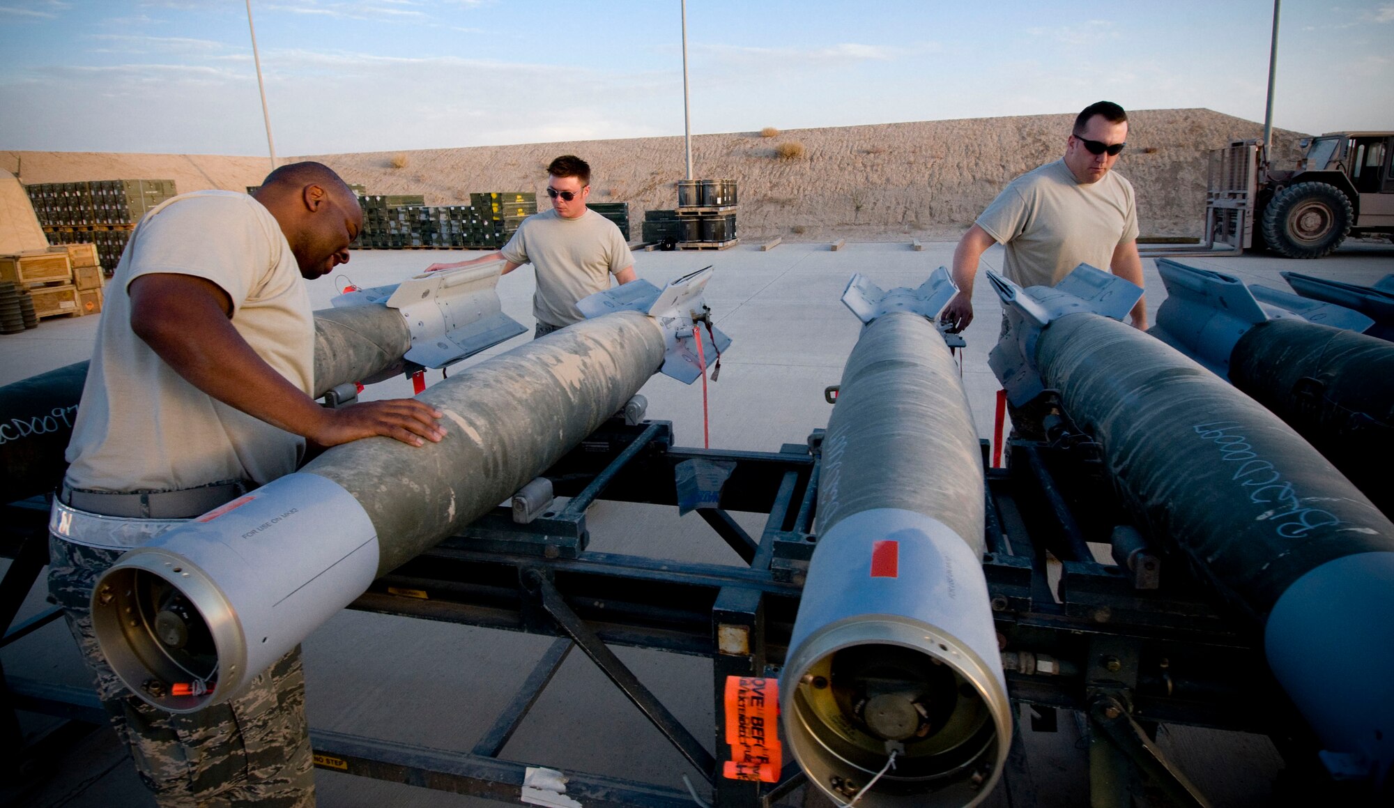 The 451st Air Expeditionary Group Logistics Flight-Ammo checks GBU-12 laser-guided bombs at Kandahar Air Field, Afghanistan, Oct. 27, 2008. The three-man team frequently handles munitions separately, delegating responsibilities to work on multiple projects, but some tasks require all three to work together to get the job done. (U.S. Air Force photo by Staff Sgt. Samuel Morse/Released)