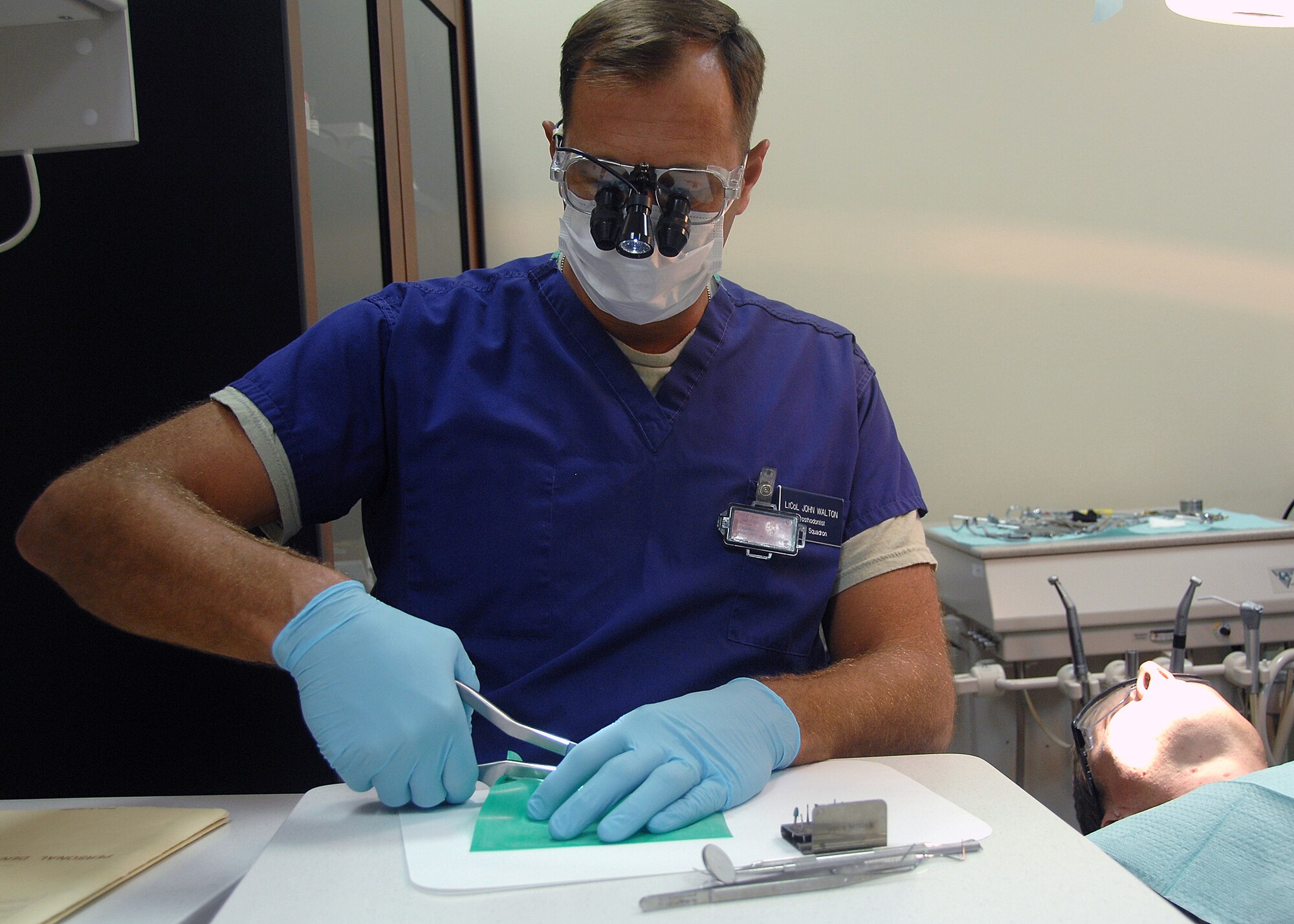 SOUTHWEST ASIA -- Lt. Col. John Walton, 386th Expeditionary Medical Group dentist, prepares a dental dam before performing repairs on Australian Air Force Sergeant Courtenay Brockman's broken tooth during an emergency visit on Nov. 4 at an air base in Southwest Asia. The dental clinic provides urgent care treatment to 386th Air Expeditionary Wing members, sister services and coalition members. Colonel Walton is deployed from Wright-Patterson Air Force Base, Ohio. (U.S. Air Force photo/Tech. Sgt. Raheem Moore)