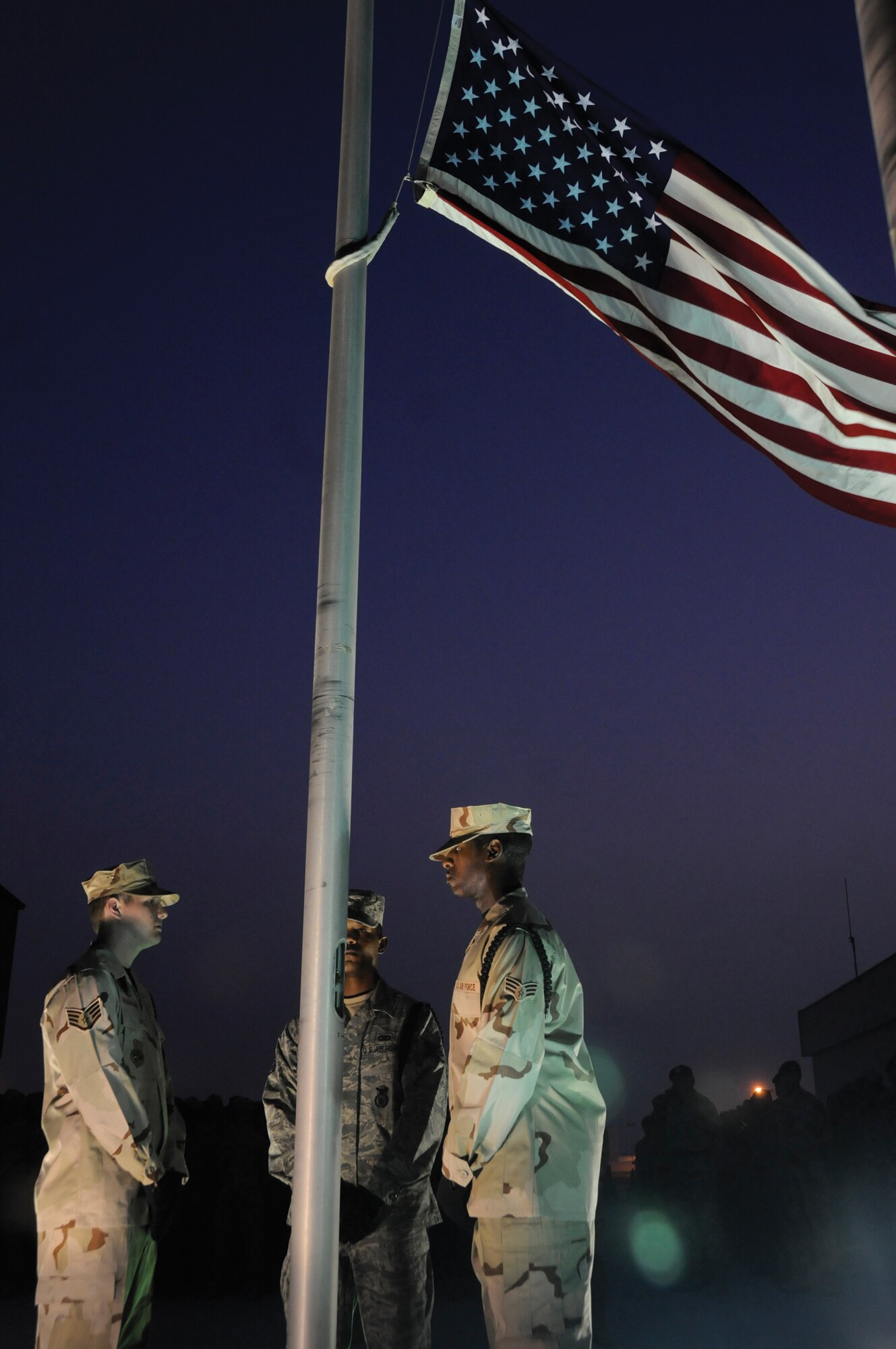 Staff Sgt. Blake Casagrande, 379th Expeditionary Civil Engineer Squadron (left), Staff Sgt. Curtis Wynn, 379th Expeditionary Security Forces Squadron, (middle) and Senior Airman Dereck Hutcherson, 379 ECES, stand solemnly before this year’s 9/11 remembrance retreat ceremony at an undisclosed location in Southwest Asia. (U.S. Air Force photo by Staff Sgt. Darnell T. Cannady)