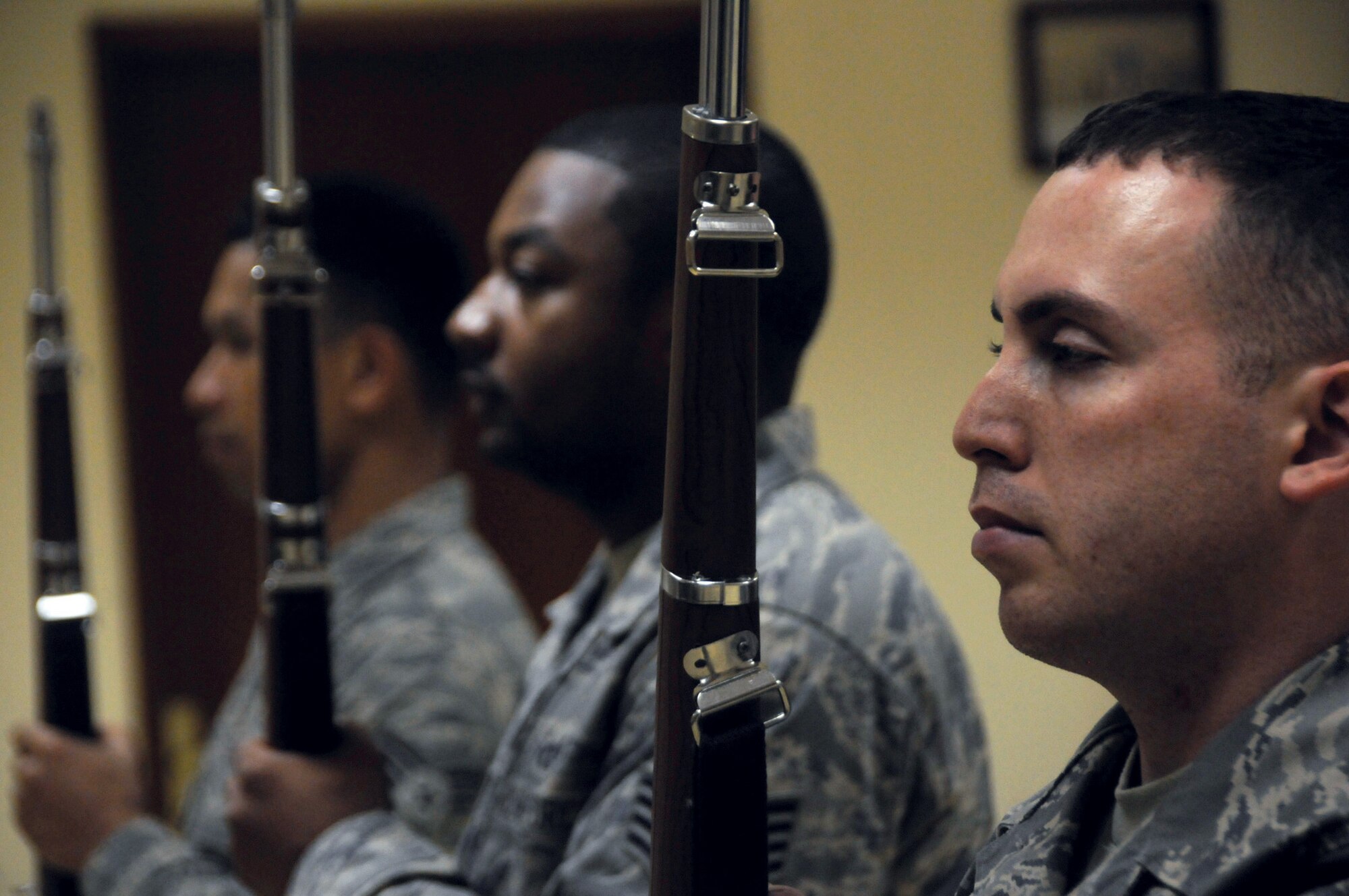 Staff Sgt. Jason Lichau, 379th Expeditionary Communications Squadron, Staff Sergeant Lorenzo Livingston, 1st Expeditionary Red Horse Group, and Senior Airman Roppert Beltran, 379 ECES, perform the command of port arms using a M1 Garand replica during honor guard practice Oct. 28. Sergeant Lichau, a native of Maryville, Tenn., is deployed from Davis-Monthan Air Force Base, Ariz., Sergeant Livingston, a native of Myrtle Beach, S.C., is deployed from Davis-Monthan, and Airman Beltran, a native of Salem, Ore., is deployed from McChord AFB, Wash. (U.S. Air Force photo by Staff Sgt. Darnell T. Cannady)