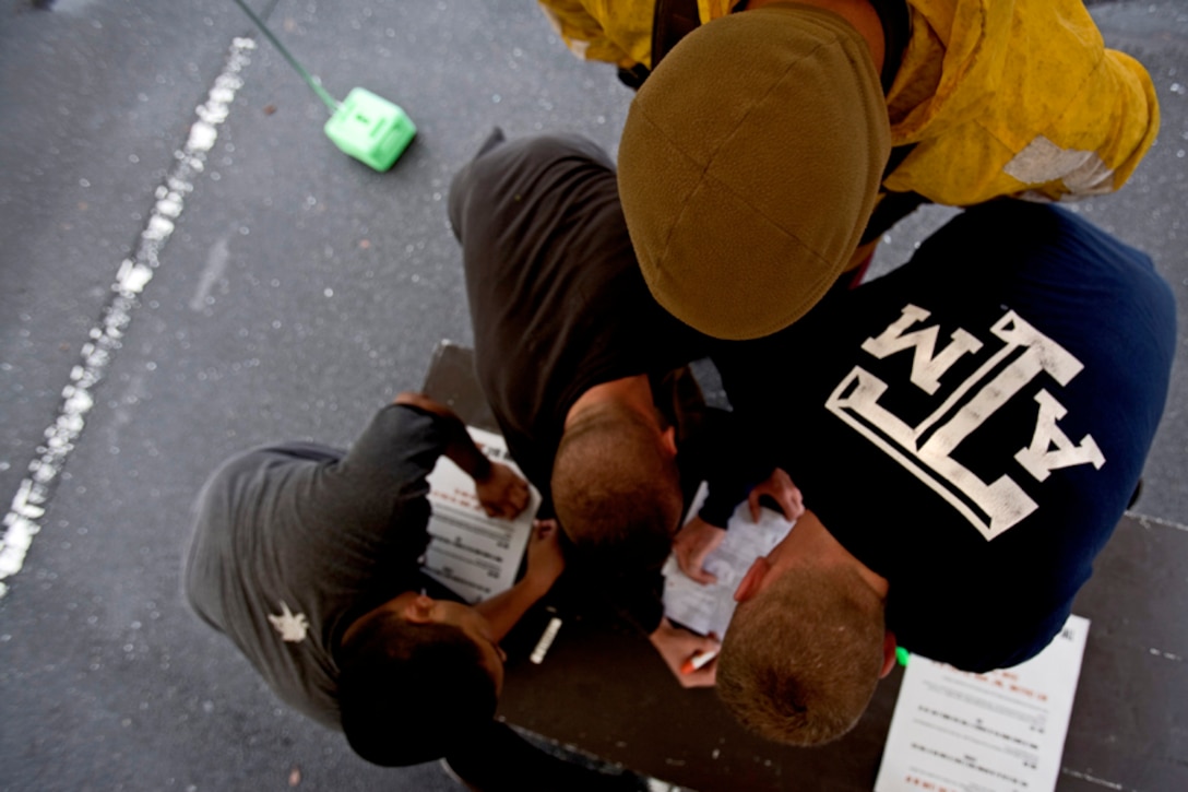 Julian Briones, Cory Thornton, Byron Whisnant and Brandon Carlton attempt to recall their Marine Corps knowledge as they complete a knowledge quiz during the Amazing Race held here Saturday.