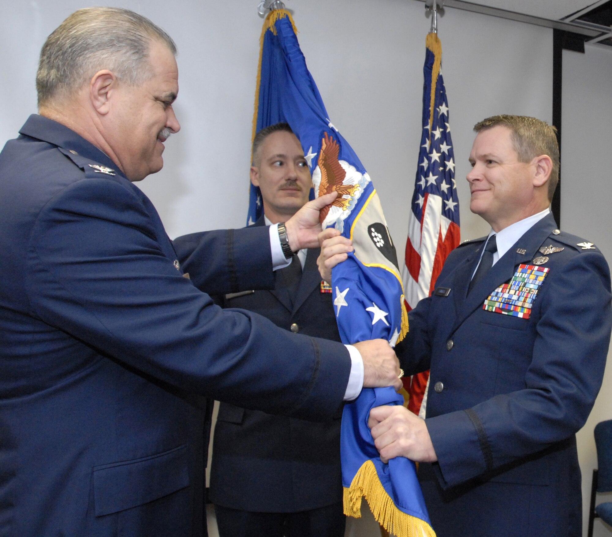 Col. Jerry Fenwick, right, accepts the flag of the 442nd Medical Squadron from Col. Mark Clemons, 442nd Fighter Wing commander, during a change of command ceremony Nov. 9 in the Whiteman  Air Force Base Clinic.  Colonel Fenwick, who is on the clinical staff at Cox Health Hospitals in Springfield, Mo., and is a former active -duty Army physician, took command of the medical squadron  during the event.  The 442nd Medical Squadron maintains the health and welfare of approximately 1,200 Air Force reservists in the 442nd Fighter Wing, based at Whiteman AFB, Mo.  (U.S. Air Force photo/Maj. David Kurle)