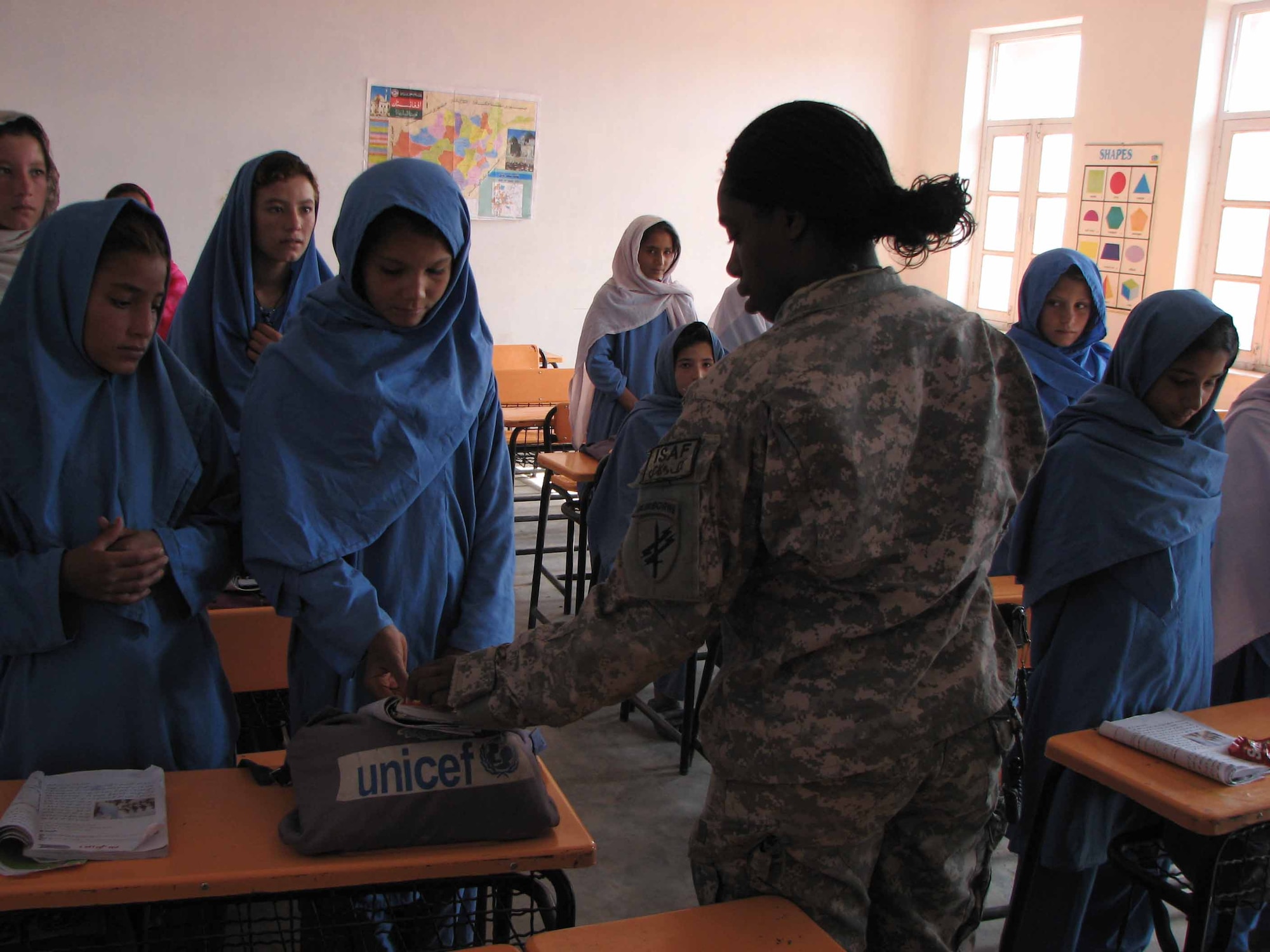 Army 1st Lt. Rhoda Young, civil affairs, passes out candy to children in the Hope of Mother School, a private school in Nangarhar Province Nov. 3.  She is part of the Nangarhar Provincial Reconstruction Team.  The PRT is made up of Airmen and Soldiers from around the world and is charged with assisting the provincial government in improving security, governance and reconstruction.  Her hometown is Battle Creek, Michigan.  (U.S. Air Force photo by Capt. J. Elaine Hunnicutt/Released)