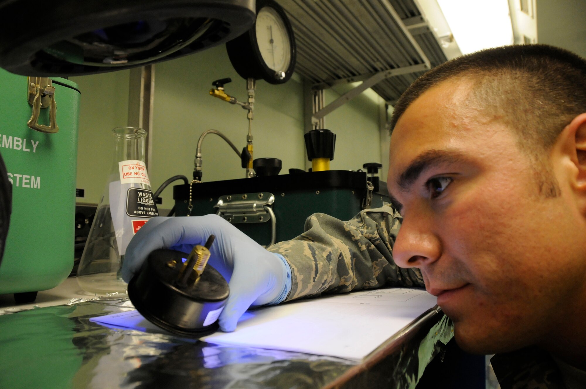 Staff Sgt. Rodney Bonham, precision measurement equipment laboratory craftsman assigned to the 379th Expeditionary Maintenance Squadron, uses an ultraviolet light to check for corrosion in an oxygen gauge Nov. 8, at an undisclosed air base in Southwest Asia.  Sergeant Bonham, a native of Tulsa, Okla., is deployed from Charleston Air Force Base, S.C., in support of Operations Iraqi and Enduring Freedom and Joint Task Force-Horn of Africa. (U.S. Air Force photo by Staff Sgt. Darnell T. Cannady/Released)