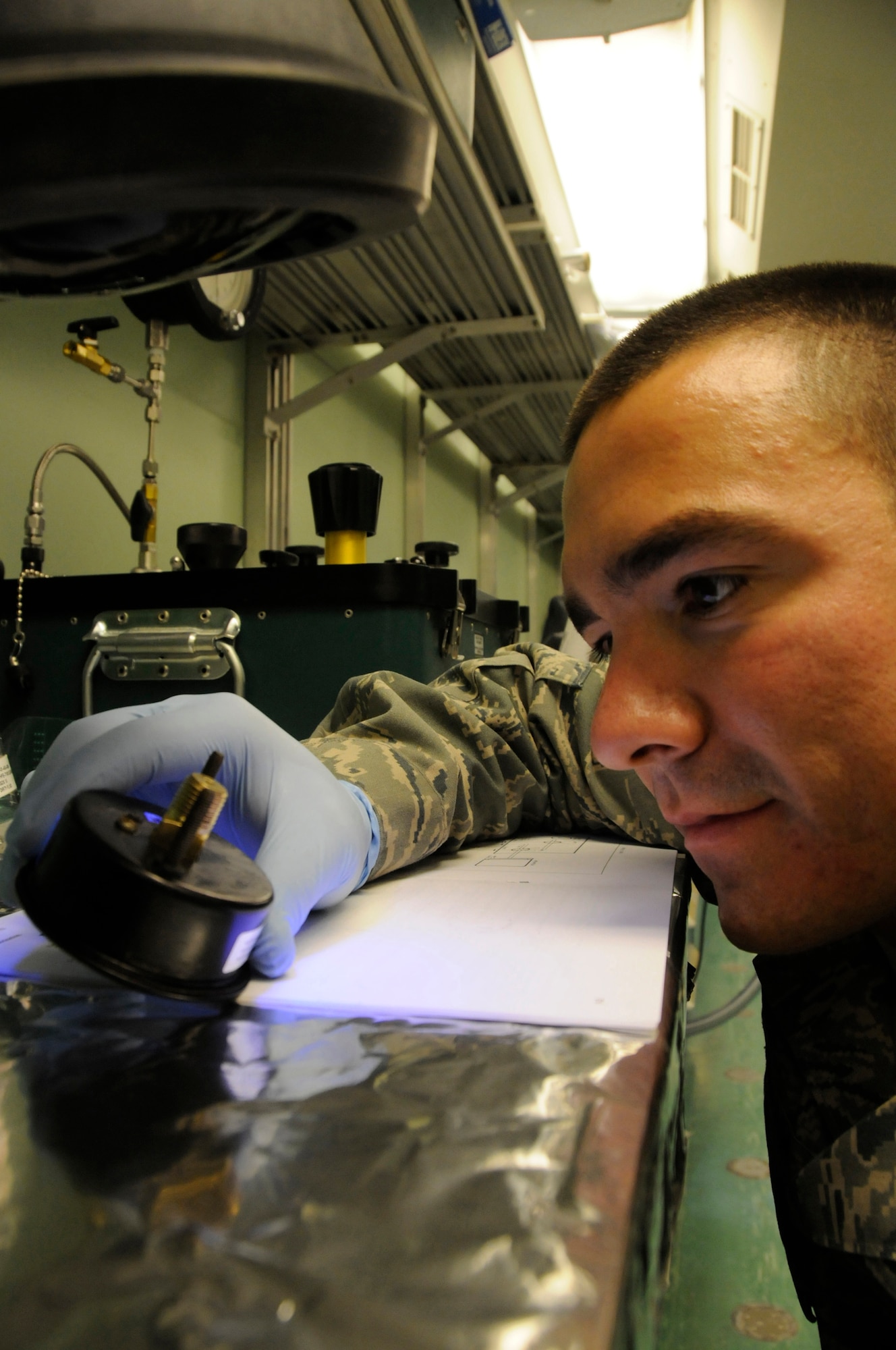 Staff Sgt. Rodney Bonham, precision measurement equipment laboratory craftsman assigned to the 379th Expeditionary Maintenance Squadron, uses an ultraviolet light to check for corrosion in an oxygen gauge Nov. 8, at an undisclosed air base in Southwest Asia.  Sergeant Bonham, a native of Tulsa, Okla., is deployed from Charleston Air Force Base, S.C., in support of Operations Iraqi and Enduring Freedom and Joint Task Force-Horn of Africa. (U.S. Air Force photo by Staff Sgt. Darnell T. Cannady/Released)