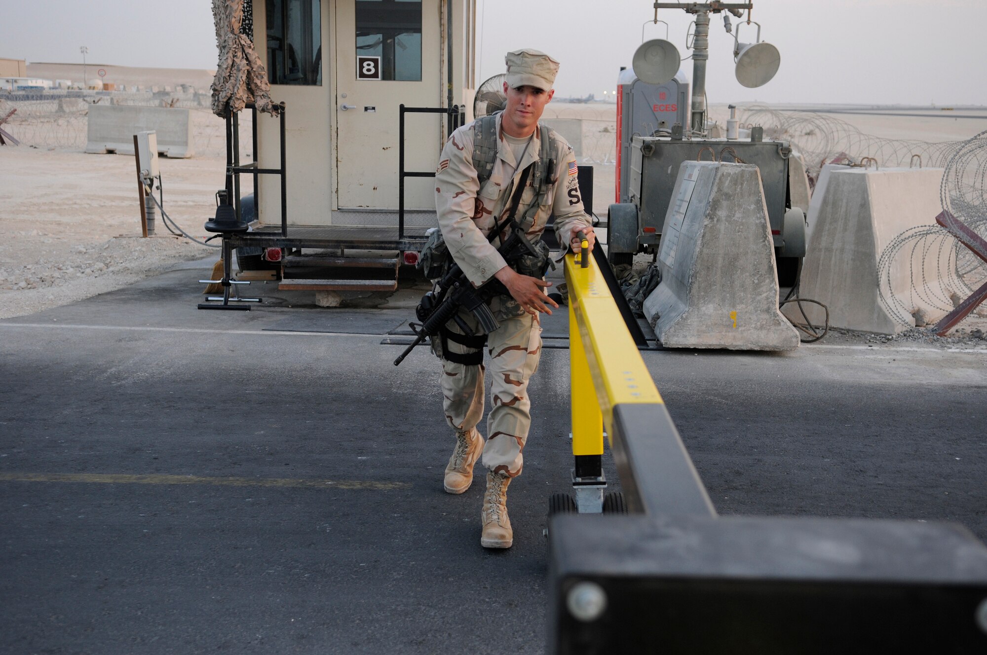 Senior Airman Tyler Fort, entry controller assigned to the 379th Expeditionary Security Forces Squadron, rolls a wheeled entry control point barrier open, Nov. 7, at an undisclosed air base in Southwest Asia.  The wheeled barrier is being evaluated at this check point to determine if it meets the needs of the security personnel for efficient and effective operation, prior to being installed at other ECPs around the base.  Airman Fort, a native of Phoenix, Ariz., is deployed from Randolph Air Force Base, Texas, in support of Operations Iraqi and Enduring Freedom and Joint Task Force-Horn of Africa.  (U.S. Air Force photo by Tech. Sgt. Michael Boquette/Released)
