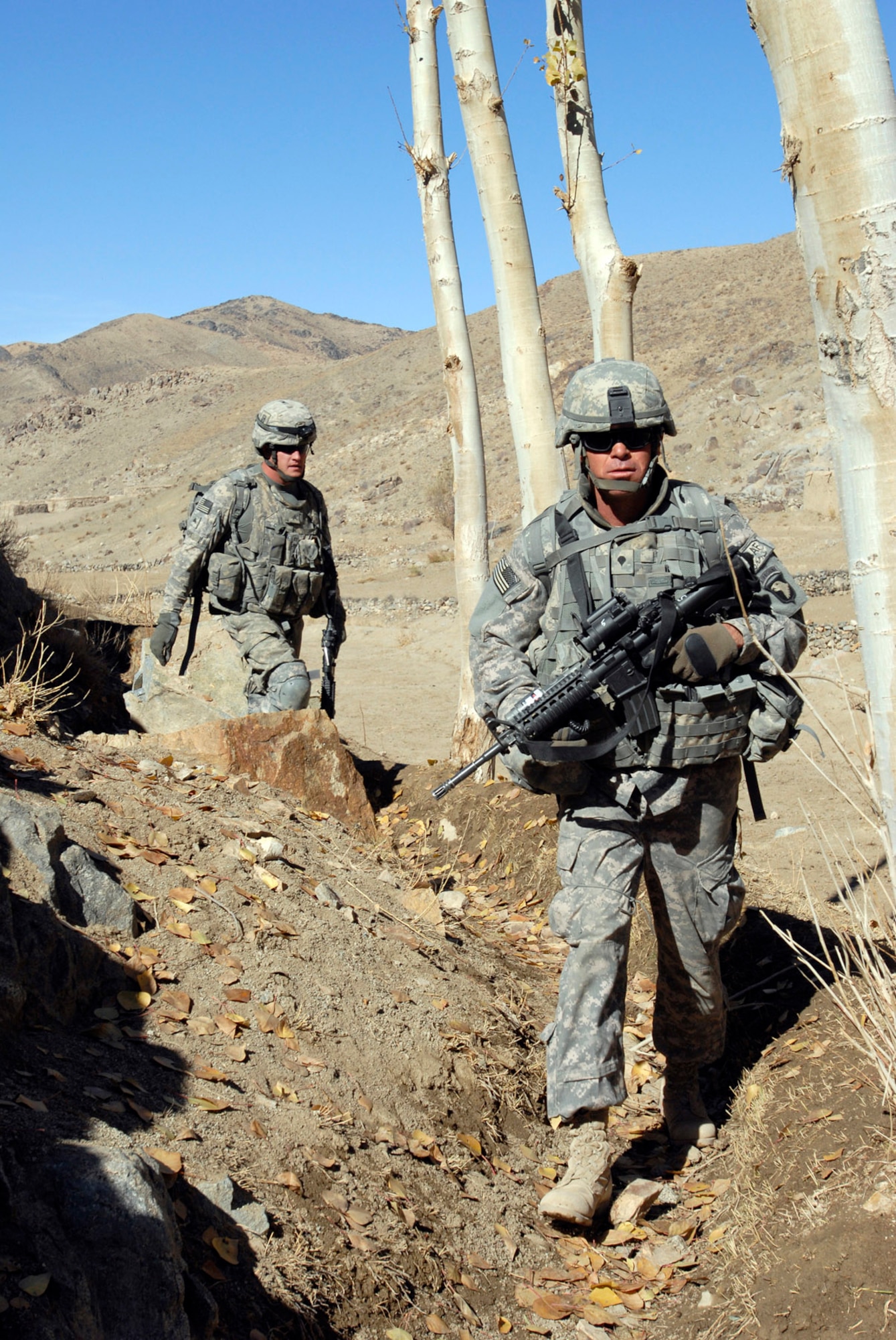 Two soldiers with the 101st Airborne Division follow a goat path while patrolling a small valley during an air assault in eastern Afghanistan, Nov. 4.  (Photo by Spc. Mary L. Gonzalez)