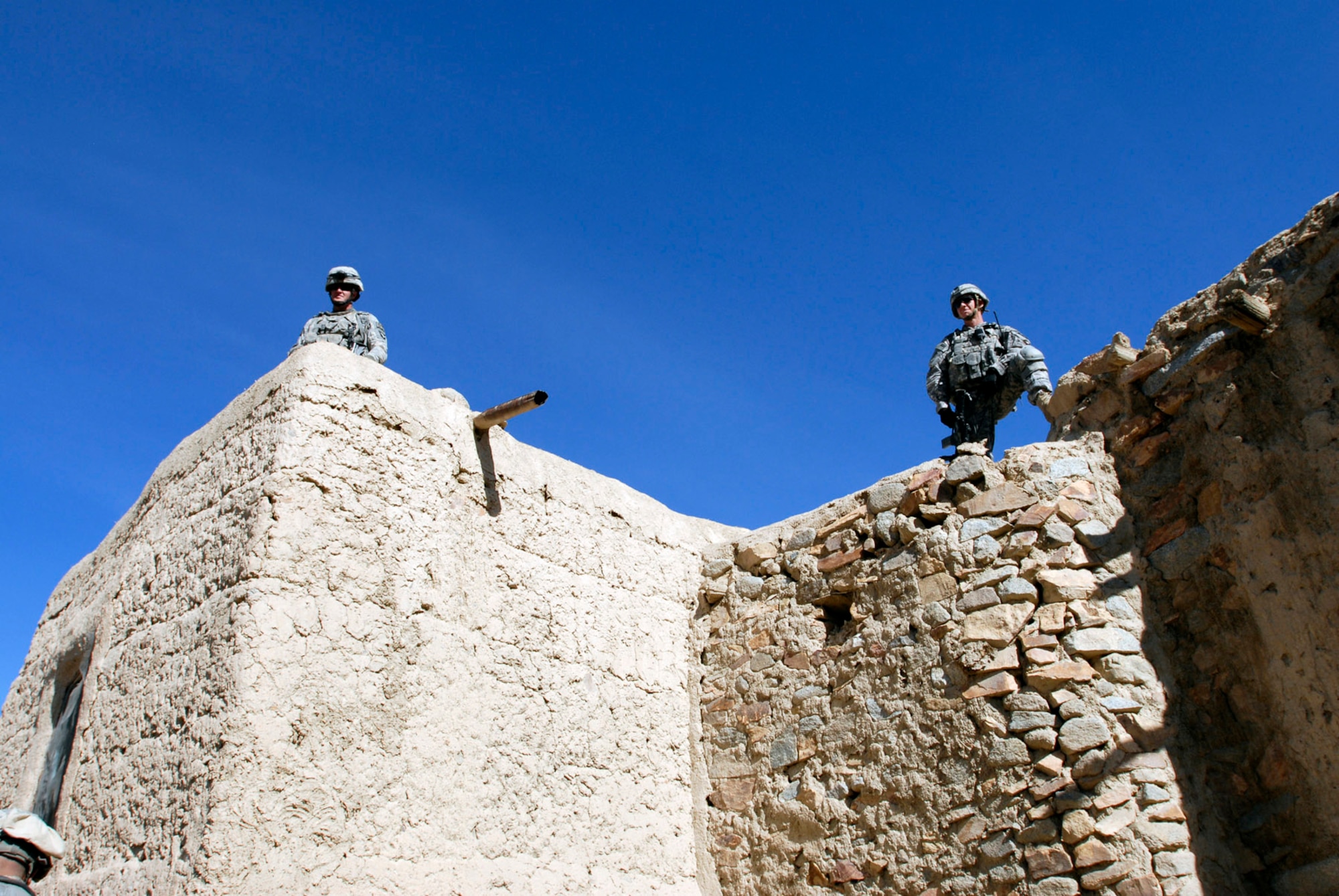 Soldiers with Alpha Company, 101st Division Special Troops Battalion, 101st Airborne Division, survey the area from a roof top in a small village, Nov. 4, 2008.  They, and more than 100 other 101st Soldiers air assaulted into a narrow valley and searched a village for IED making materials and facilities.  (Photo by Spc. Mary L. Gonzalez, CJTF-101 Public Affairs)
