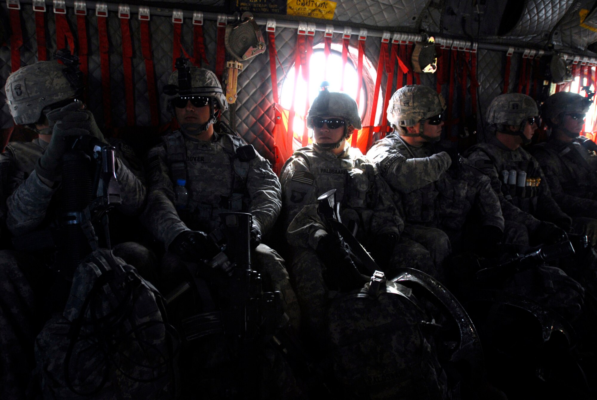A Soldier with Alpha Company, 101st Division Special Troops Battalion, 101st Airborne Division, is haloed by light shining through a Chinook helicopter's window as he flie out from Bagram Air Field, Afghanistan to air assault into a narrow valley to search for IED making materials Nov. 4.  (Photo by Spc. Mary L. Gonzalez, CJTF-101 Public Affairs)