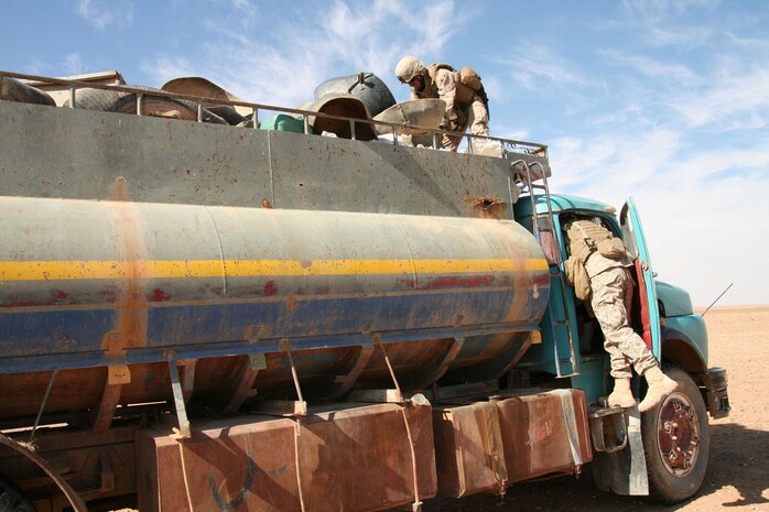 Reserve Marines from Weapons Company, 2nd Battalion, 25th Marine Regiment, Regimental Combat Team 5 search a vehicle parked near the Iraq-Syrian border during a routing security patrol Nov. 9.  The vehicle was owned and operated by Iraqi shepherds whose flocks graze on the sparse patches of grass that periodically spring up in the desert.  ::r::::n::