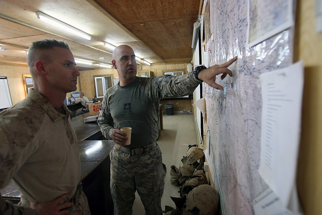 Sergeant 1st Class James L. Price, platoon sergeant, scout platoon, Eagle Troop, 3rd Armored Cavalry Regiment, points out places of interest to Capt. Keith P. Tighe, commanding officer, Company D, 1st Light Armored Reconnaissance Battalion, 1st Marine Division, during a battle space changeover meeting at Combat Outpost Heider Nov. 10. Price, 42, Houston, Texas, and Tighe, 39, Sacramento, Calif., talked at length about possible insurgency hot spots and trade routes in Tighe’s new area of operations. The “Diablos” of Company D accepted responsibility for battle space in the Nineweh province Nov. 10. The Marines relieved soldiers from the Army’s 3rd Armored Cavalry Regiment. Mission accomplishment for the Diablos is to enable stabilization of Mosul by maintaining presence in towns, villages and along trade routes used by FFF and insurgents. The Marines make up one element of the first Marine Air Ground Task Force outside Anbar in Iraq since 2004. They traveled to the Nineweh province to kick off Operation Defeat Al Qaeda in the North II, an operation aimed at stamping out the insurgency just west of the restive city of Mosul.