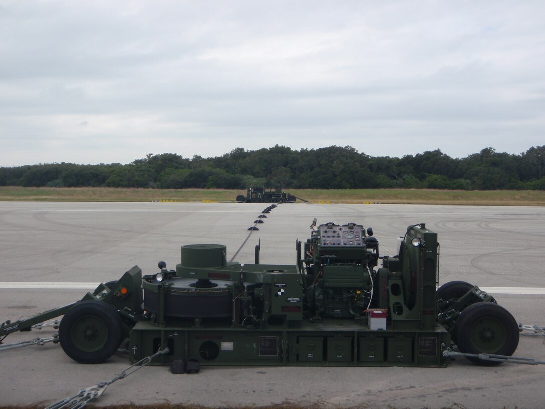 An M-31 Marine Corps Expeditionary Arresting Gear System is installed and ready for use on a runway. Marines with the 2nd Marine Aircraft Wing, based out of Marine Corps Air Station New River, N.C. and 3rd MAW, from MCAS Miramar, Calif. implemented the system for the 2nd Annual Space & Air Show at Kennedy Space Center Nov. 9.