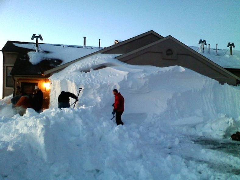 Ellsworth residents shovel snow blocking a garage in base housing here, Nov. 10.  A  Nov. 5 blizzard resulted in massive accumulations of snow, mostly due to drifting,closing the base for two days.  In addition to this, the drifts made driving difficult on surrounding highways and in the surrounding communities.  (U.S. Air Force photo/Senior Airman Jenniffer Onukwugha)