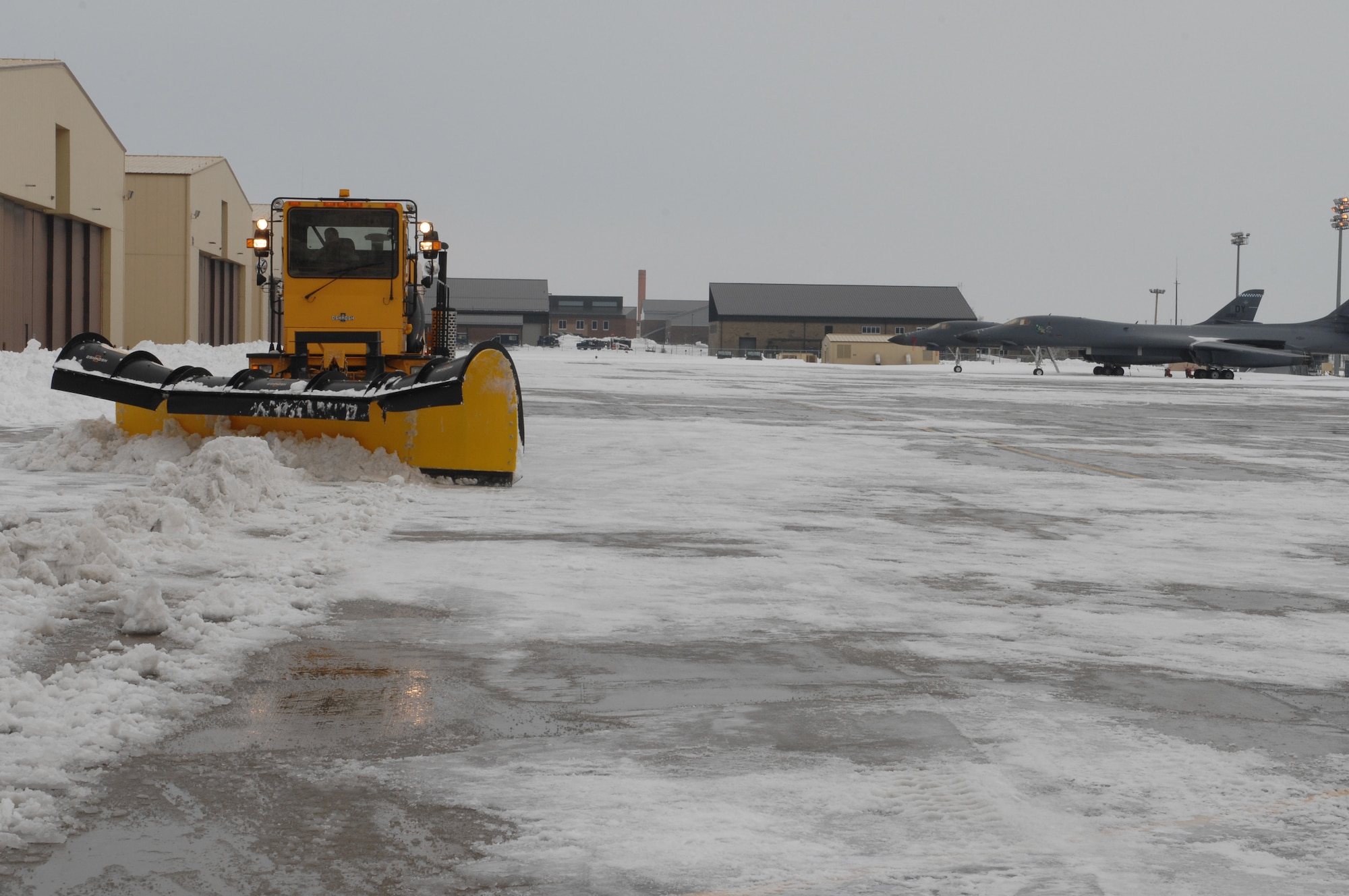 Roger Lutz, 28th Civil Engineering Squadron air field equipment operator, plows snow and ice off of the flightline here, Nov. 10. A blizzard on Nov. 5, covered the base with approximately 10 inches of snow closing the base for two days. (U.S. Air Force photo/Airman 1st Class Joshua J. Seybert)