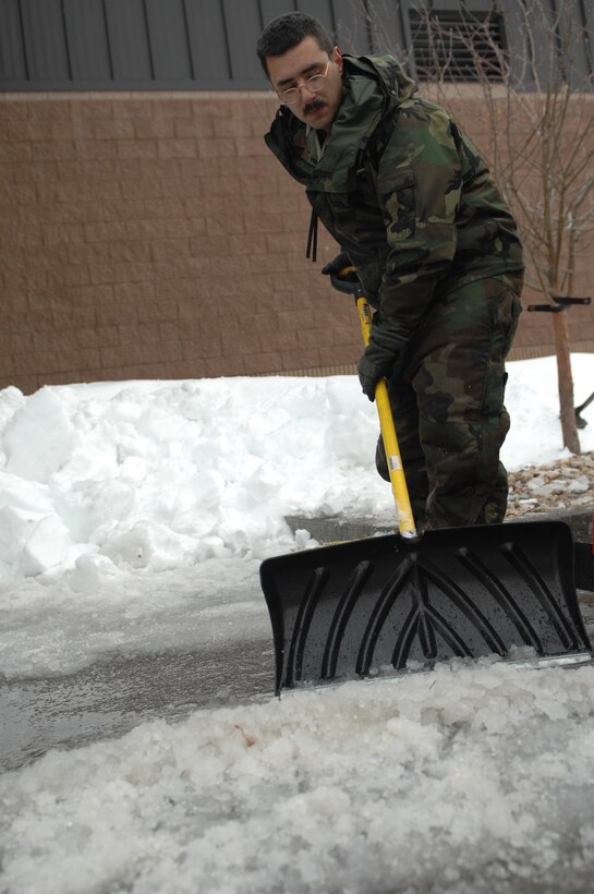Senior Airman Christopher Witt, 28th Aircraft Maintenance Squadron aerospace maintenance journeyman, shovels snow behind the 37th Bomb Squadron building here, Nov. 10. Airmen took time removing snow and ice due to a blizzard on Nov. 5, which closed the base for two days. (U.S. Air Force photo/Airman 1st Class Joshua J. Seybert)