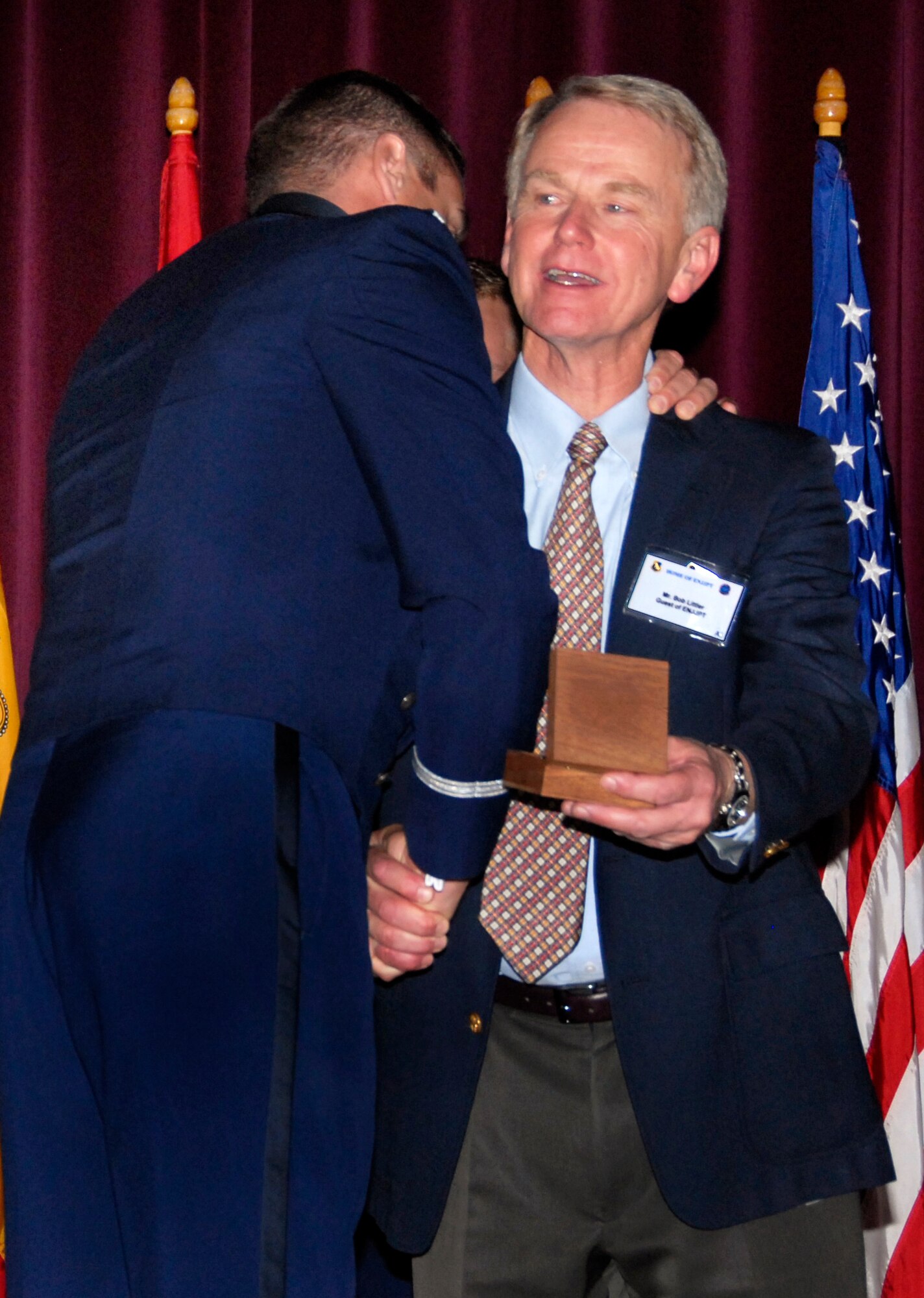 Second Lt. Ryan Bodenheimer shakes Bob Littler's hand and gives him a hug after presenting him with his son's, 2nd Lt. Alec Littler, wings posthumously during a ceremony at the Euro-NATO Joint Jet Pilot Training Porgram graduation Nov. 7 at the base theater. Lieutenant Littler was killed May 1 during a T-38 Talcon crash. He would have graduated with Class 08-08. (U.S. Air Force photo/Harry Tonemah)