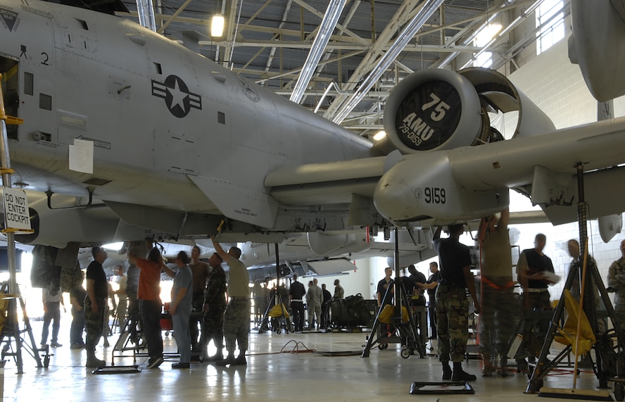 MOODY AIR FORCE BASE, Ga. -- Forty Airmen from eight bases begin the task of simultaneously preparing five A-10C models for wing section repair here Nov. 7 . Airmen not assigned to Moody will learn how to repair the A-10C wing section and return home station to share this knowledge within their units. In order to accomplish these repairs, Airmen must climb into tiny compartments within the wing to reach certain areas. (U.S. Air Force Photo by Senior Airman Javier Cruz)