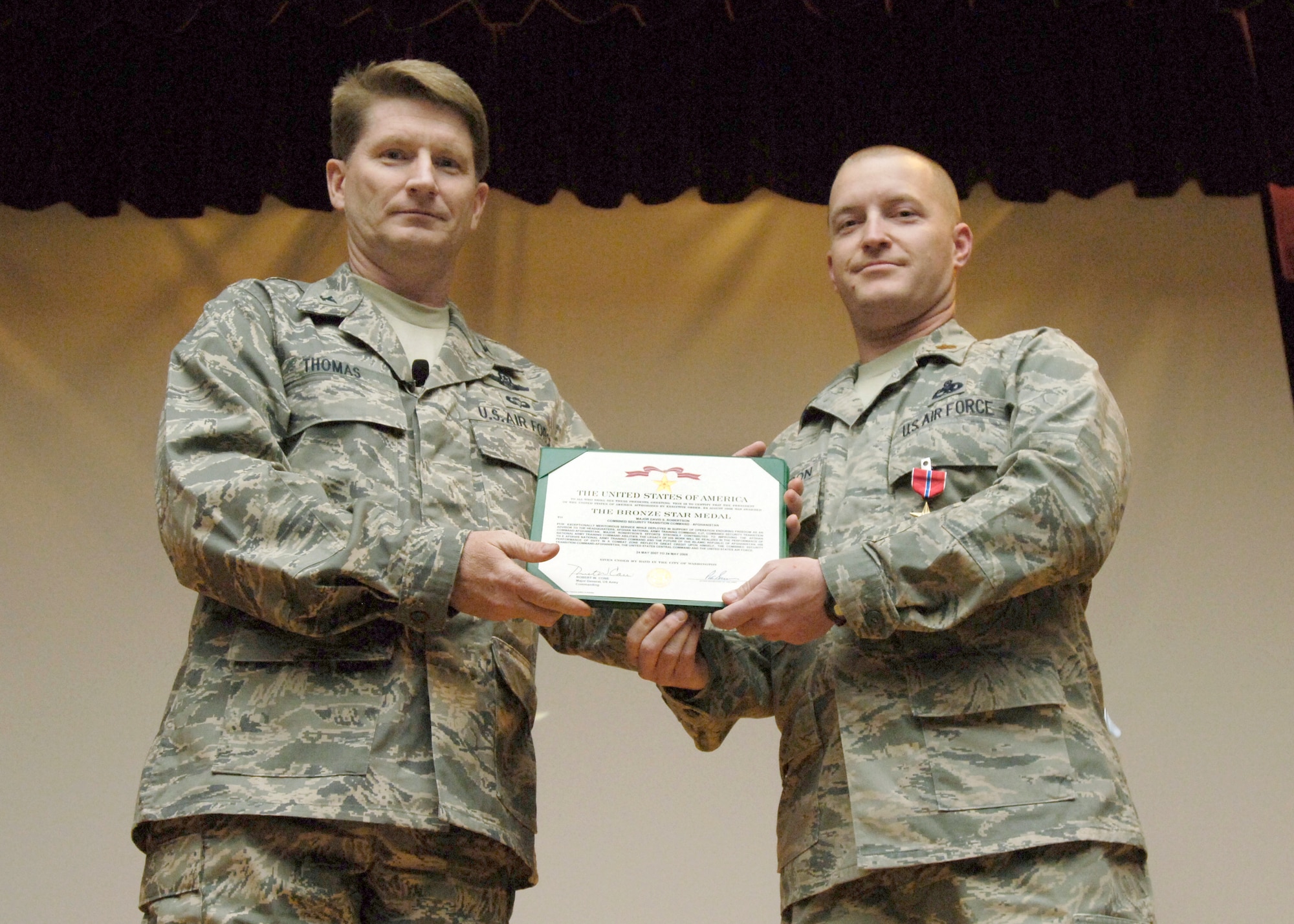 FAIRCHILD AIR FORCE BASE, Wash. – Col. Robert Thomas, 92nd Air Refueling Wing commander, presents the Bronze Star Medal to Maj. David Robertson, 92nd Maintenance Group commander executive officer, during the Wing Commander’s Call at the theater here Nov. 5. The major received the medal for his service while deployed to Afghanistan May 2007 – 2008, where he was the headquarters staff mentor for Afghan National Command Kabul. (U.S. Air Force photo / Senior Airman Eunique Stevens)
