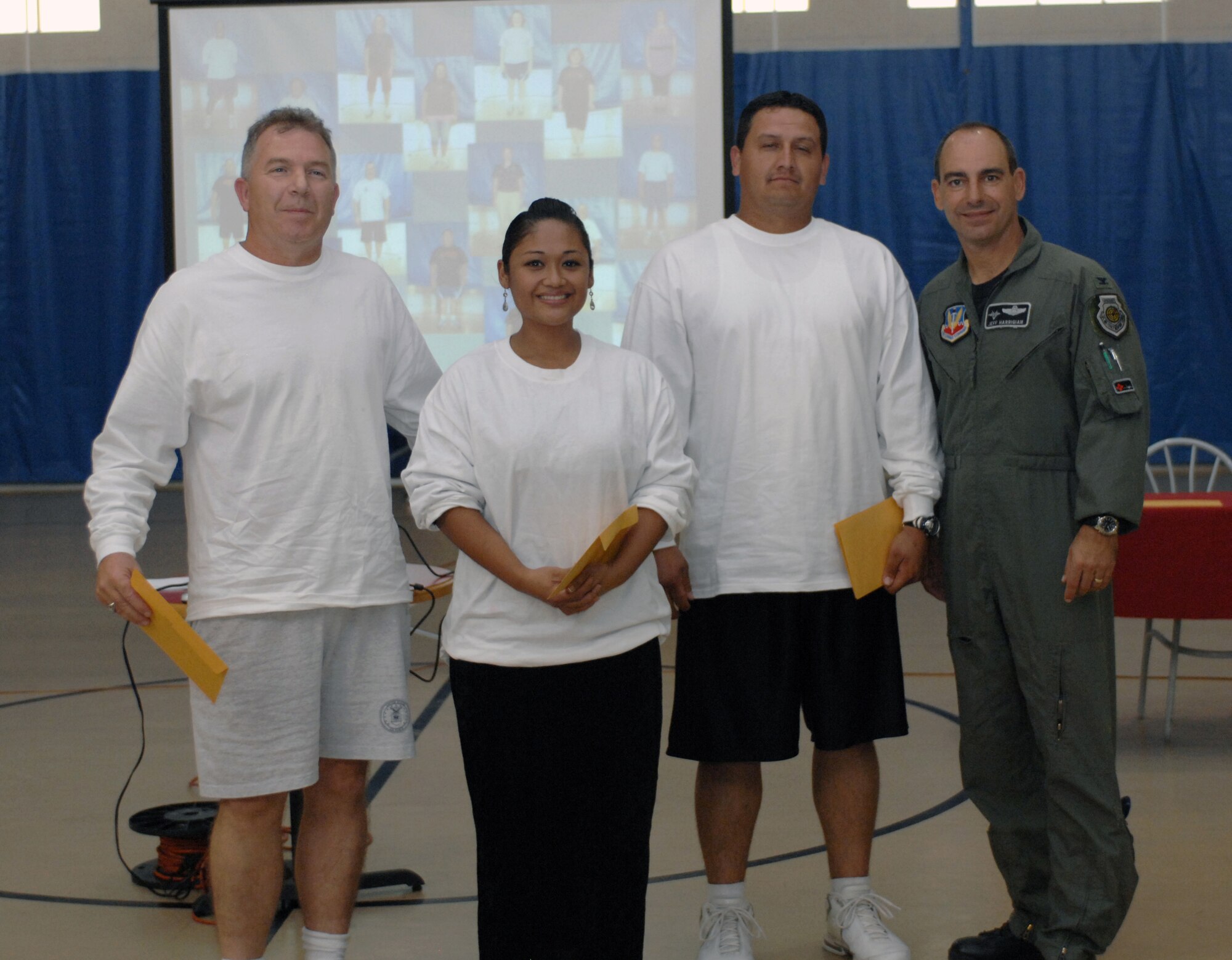 The Biggest Loser team, En Fuego, poses with Col. Jeff Harrigian, 49th Fighter Wing commander, after being announced the team with the most overall weight loss during the Biggest Loser awards ceremony at the Fitness and Sports Center at Holloman Air Force Base, N.M., Oct. 31. The team members include (from left to right) Capt. Kelvin Jack, Staff Sgt. Michelle Preston, Staff Sgt. Raul Salazar and (not photographed) Tech. Sgt. Jennifer Pahl, all from the 49th Medical Operations Squadron. En Fuego lost a total of 69.5 pounds.(U.S. Air Force photo/Airman Sondra M. Escutia)
