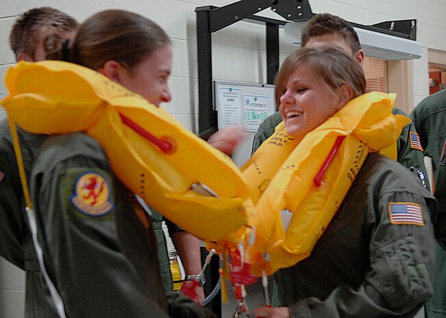 Cadet 1st Class Lauren Chaffee, left, and Cadet 2nd Class Natalie Doede try on life preservers at Aircrew Flight Equipment on Charleston AFB Nov. 8. Cadets toured the base to learn more about the operational Air Force mission. Cadets Chaffee and Doede are students at the Air Force Academy. (U.S. Air Force photo/Airman 1st Class Katie Gieratz)