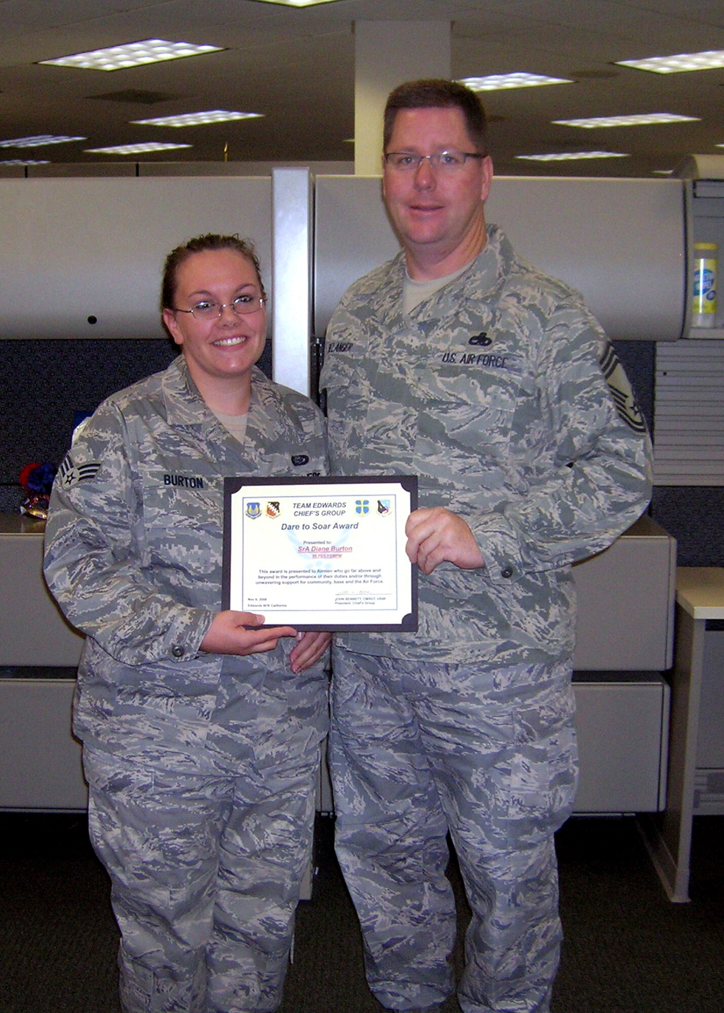 Chief Master Sgt. Mike Belanger, 31st Test and Evaluation Squadron superintendent, presents the Dare to Soar award Nov. 6 to Senior Airman Diane Burton, 95th Force Support Squadron force management technician. Airman Burton displayed leadership and superb performance to ensure manning requirements at Edwards are met. The award is presented to Airmen who go above and beyond in the performance of their duties and for their unwavering support for the community, base and the Air Force. (Air Force photo by Master Sgt. Larry Ray) 