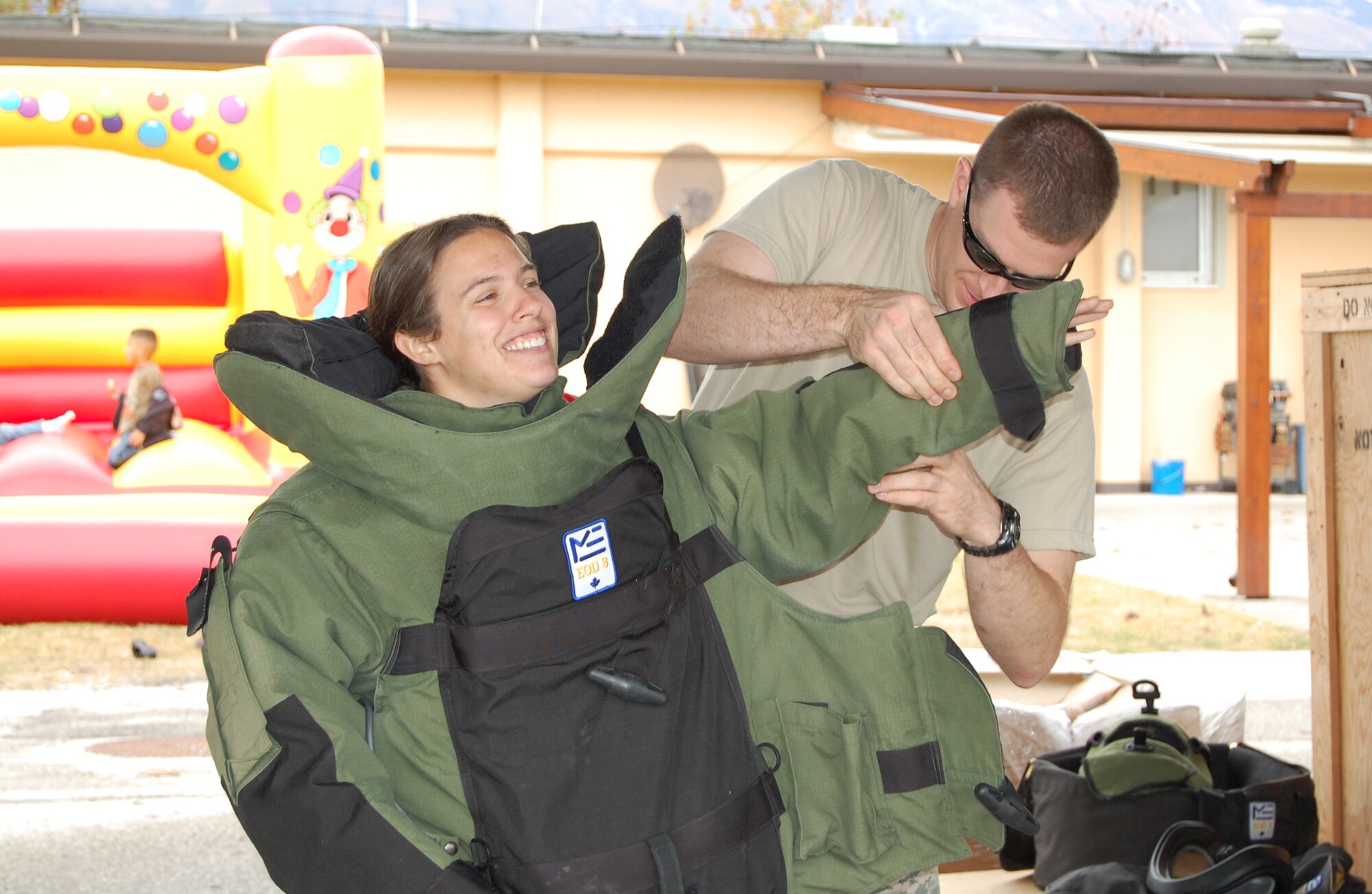 Staff Sgt. Jonathan Eaton of the 31st Civil Engineer Squadron Explosive Ordnance Flight dresses Heidi Lucas, wife of Staff Sgt. Jedd Lucas, in the EOD 8 bomb suit during the Air Force EOD Safety Day Nov. 7. The bomb suit weighs approximately 80 pounds and will protect a wearer from many of the hazards that would otherwise harm an unprotected person. (U.S. Air Force photo/Staff Sgt. Lindsey Maurice)