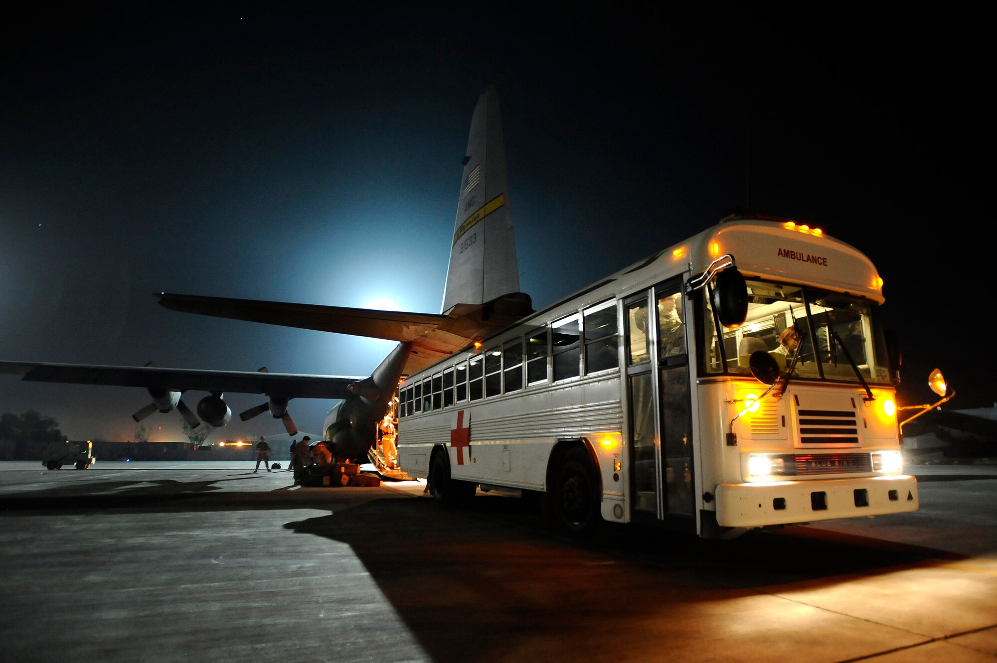 A bus from the Contingency Aeromedical Staging Facility at Joint Base Balad, Iraq, prepares to offload ambulatory and litter-bound patients from a C-130 Hercules shortly after midnight Nov. 8. Two Iraqi doctors from Iraq's Ministry of Defense accompanied a U.S. Air Force aeromedical evacuation mission to study aeromedical evacuation procedures so that they can establish an aeromedical evacuation service for the Iraqi air force. The C-130 is deployed to the 777th Expeditionary Airlift Squadron from the Wyoming Air National Guard's 153rd Airlift Wing. (U.S. Air Force photo/Airman 1st Class Jason Epley)