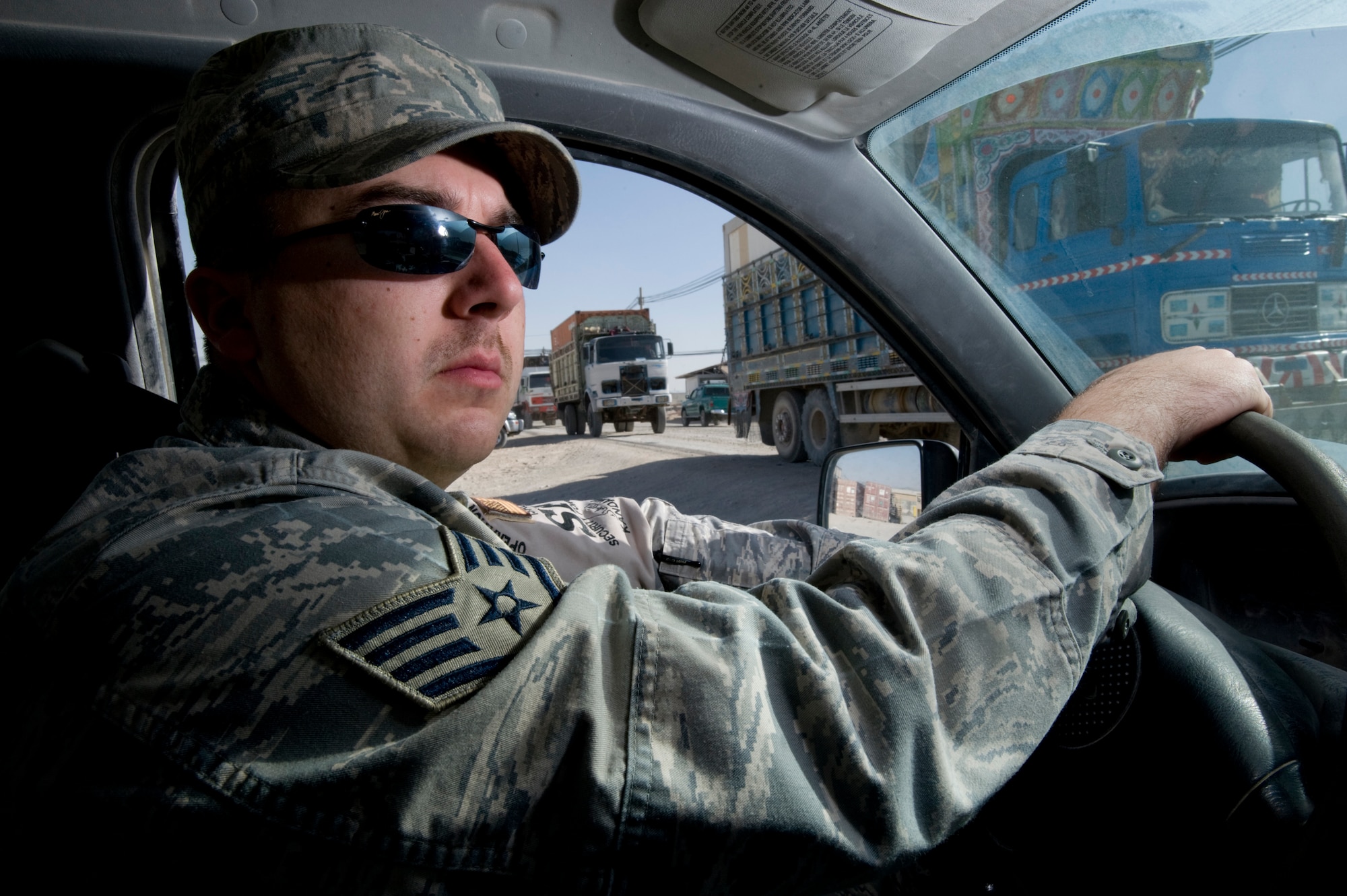 KANDAHAR AIR FIELD, Afghanistan -- Staff Sgt. Gary Riley watches a convoy of 'Jinga' trucks while on patrol. Sergeant Riley is deployed to the 755th Expeditionary Security Forces Squadron Law and Order Unit from MacDill Air Force Base, Fla. Airmen assigned to the Law and Order unit are charged with enforcing traffic laws on the NATO base, handling reports of theft and other disturbances. (U.S. Air Force photo/Master Sgt. Keith Brown)
