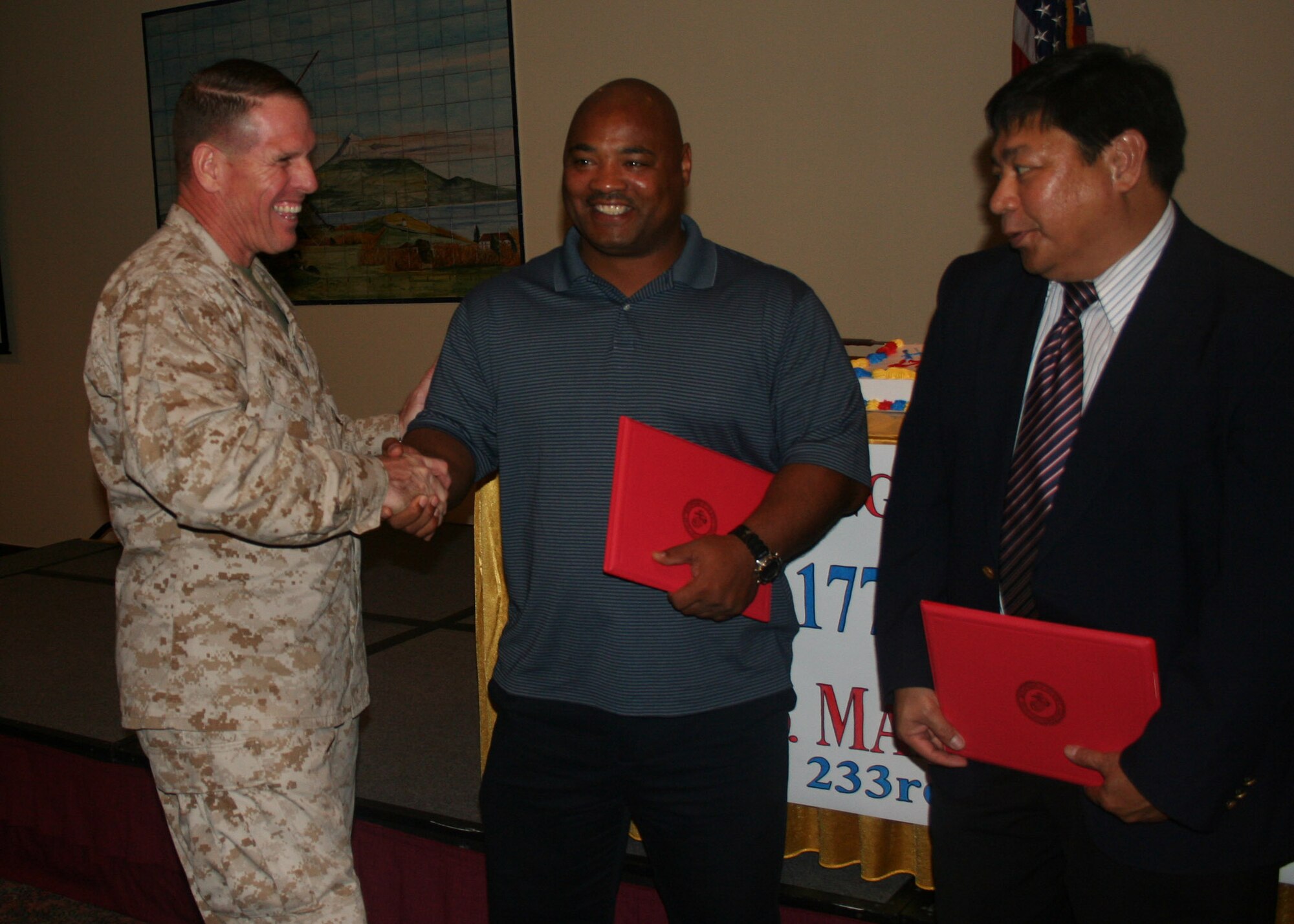 Brig. Gen. Robert Walsh, 2nd Marine Aircraft Wing assistant commander, personally thanks Gary Rucks, Terminal Manager, 838th Transportation Battalion, Azores Detachment , and Jim Marino, store director of the Lajes commissary, for their support in organizing the celebration of the Marine Corps’ 233rd birthday here at Lajes Field Nov. 9. (U.S. Air Force photo by 1st Lt. George Tobias)