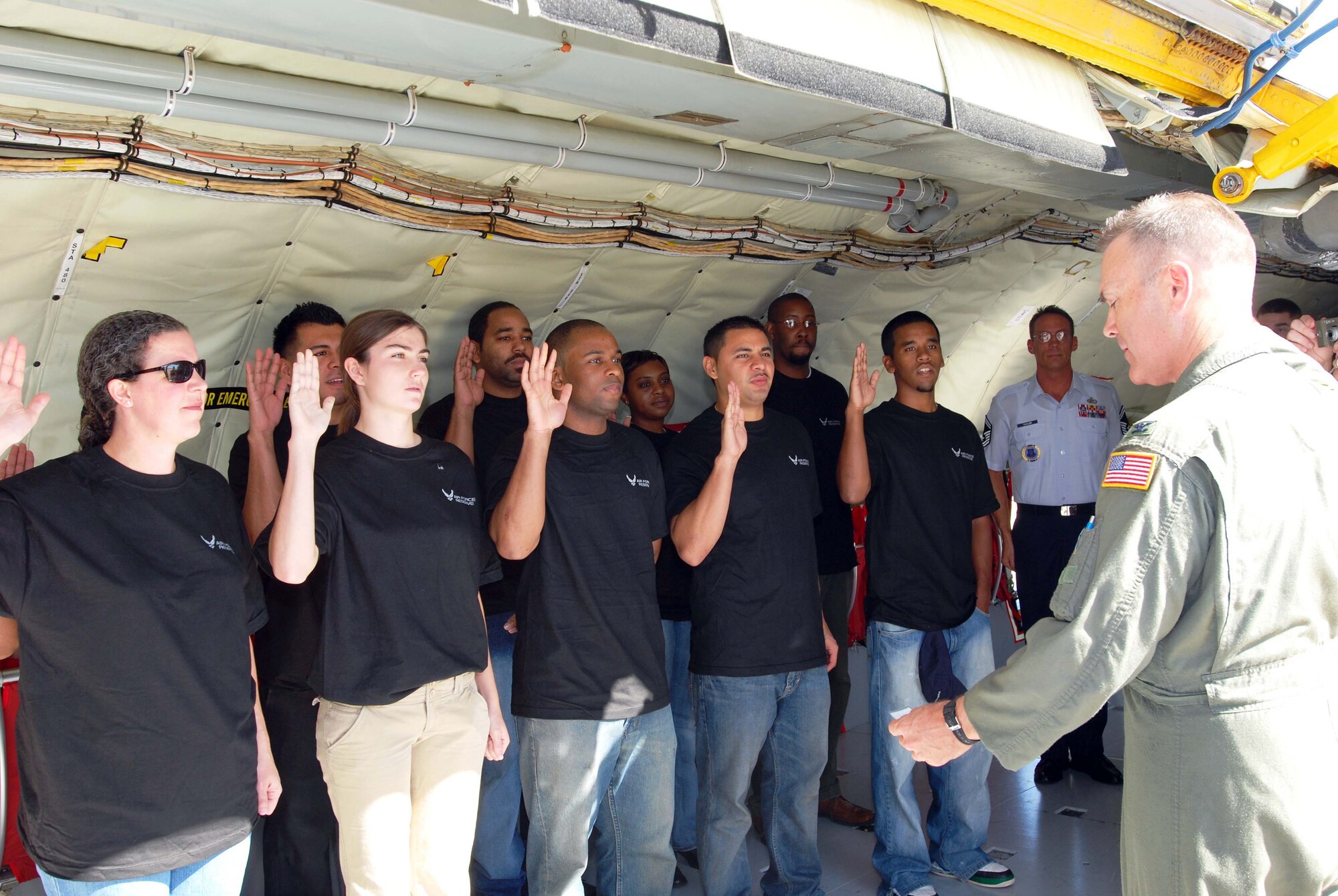 ANDREWS AIR FORCE BASE, M.D. -- (Right) Col Tim Cahoon, 459th Air Refueling Wing commander, administers the oath of enlistment aboard a KC-135 Oct 14.   Ten individuals, including prior enlisted and first term Airman, raised their right hand to take the oath.  This mass enlistment ceremony, conducted by the 459 ARW recruiting office was part of a coast to coast initiative by the Air Force Reserve Command to publicly recognize those who have signed up to serve.  (U.S. Air Force photo/Staff Sgt. Amaani Lyle)  