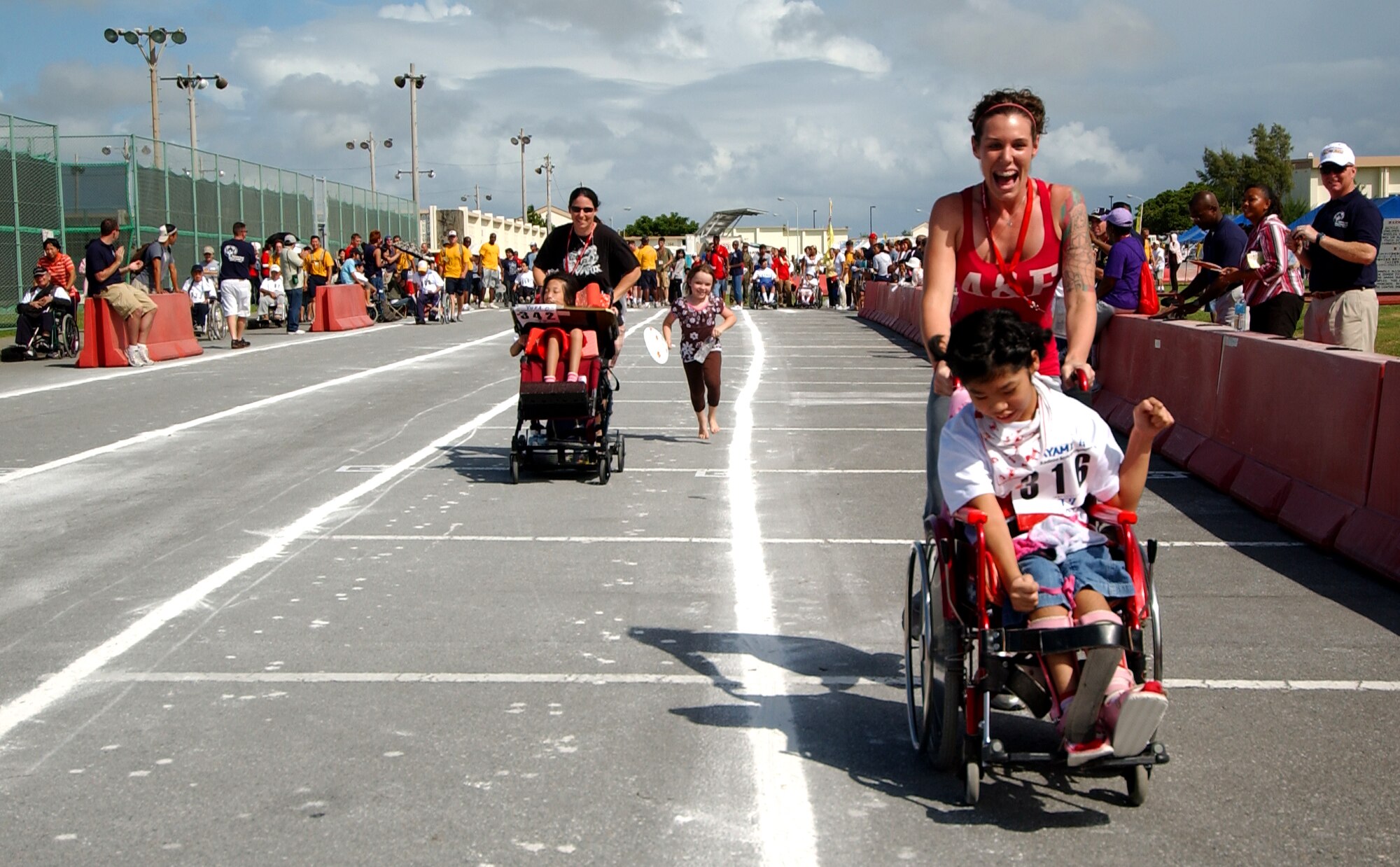 Jessa McDonald, Army spouse, pushes Ayami Goya, 10, to the finish line during a wheel chair event Nov. 8, 2008 at Kadena Air Base, Japan. Kadena hosted the 9th Annual Special Olympic Games and Art Festival for special needs Okinawan and American adult and child athletes. (U.S. Air Force photo/Tech. Sgt. Rey Ramon)                      