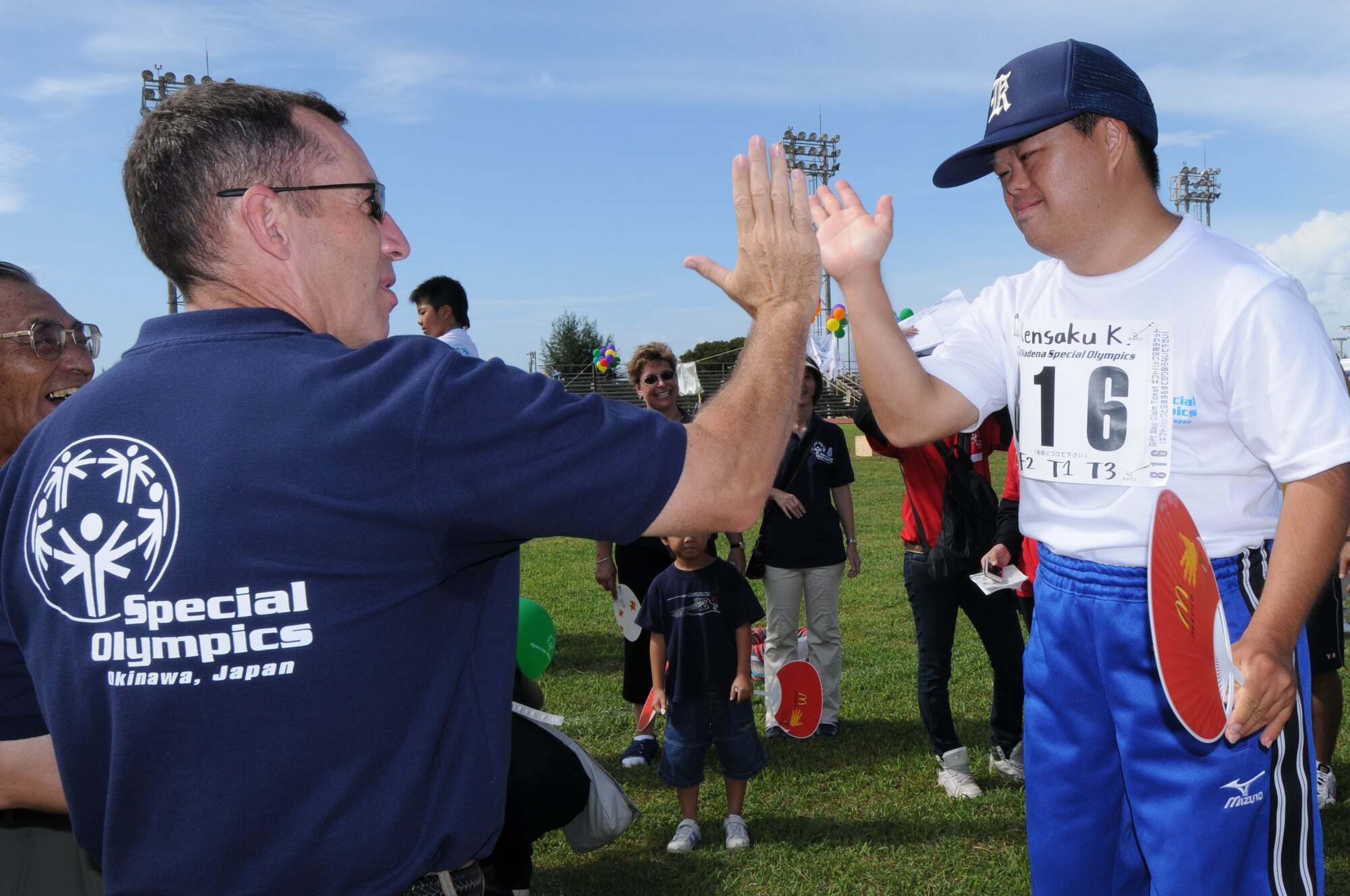 Brig. Gen. Brett  Williams, 18th Wing commander, high-fives Kensaku-san before awarding him a gold medal for running the 30 meter dash at the Kadena Special Olympics Nov. 8, 2008, Kadena Air Base, Japan. Kadena hosted the 9th Annual Special Olympic Games and Art Festival for special needs Okinawan and American adult and child athletes.   (U.S. Air Force photo/Airman 1st Class Amanda Grabiec)                           