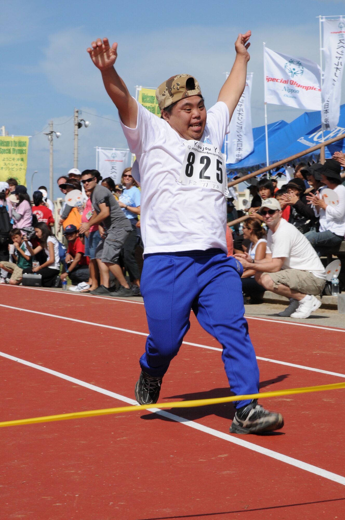 Koujou-san, a Special Olympics participant, raises his hands in excitement after crossing the finish line during the 30 meter dash Nov. 8, 2008, Kadena Air Base, Japan. Kadena hosted the 9th Annual Special Olympic Games and Art Festival for special needs Okinawan and American adult and child athletes. (U.S. Air Force photo/Airman 1st Class Amanda Grabiec)                           