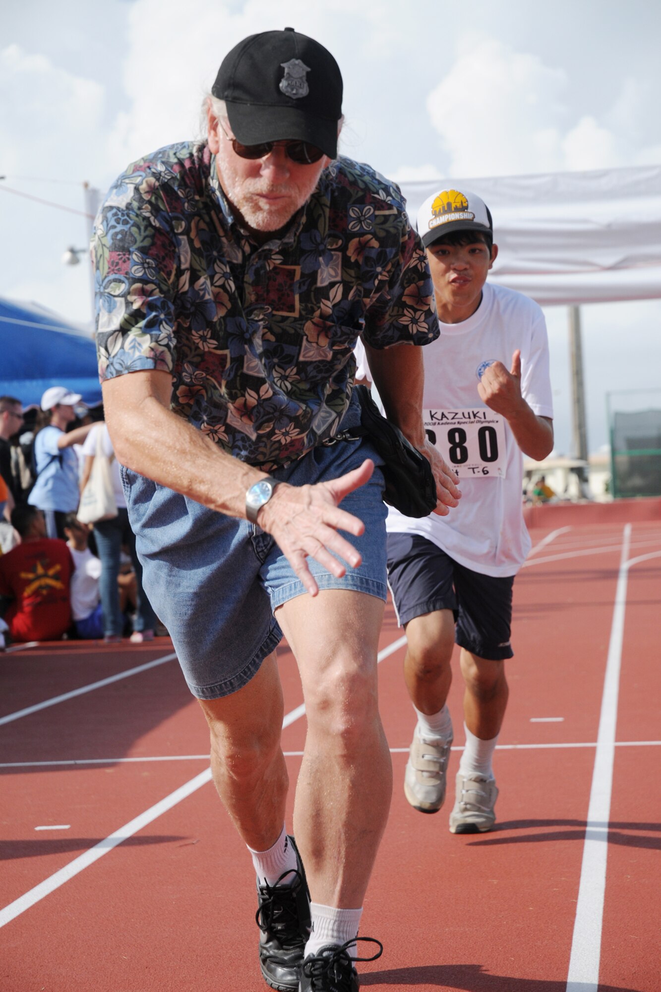 Larry Swink, a volunteer, helps Kazuki-san, 15, practice passing the baton before the 400 meter relay during the Kadena Special Olympics Nov. 8, 2008. Kadena Air Base hosted the 9th Annual Special Olympic Games and Art Festival for special needs Okinawan and American athletes. (U.S. Air Force photo/Airman 1st Class Chad Warren)
                                             