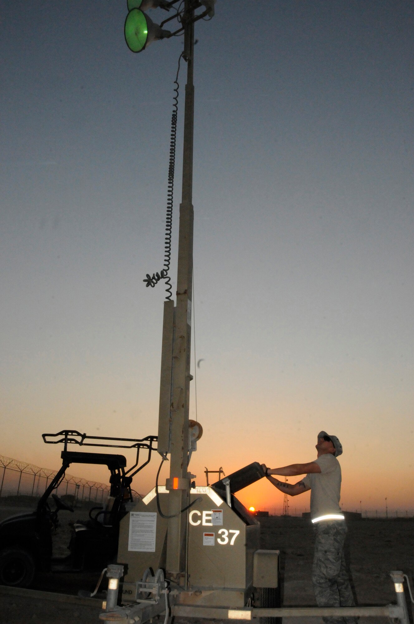 Senior Airman Christopher Seney, utility journeyman assigned to the 379th Expeditionary Civil Engineer Squadron, starts an auxiliary light unit as the sun sets, Nov. 9, at an undisclosed air base in Southwest Asia.  The lights are used to increase safety and security in the deployed environment.  Airman Seney is deployed from Scott Air Force Base, Ill., in support of Operations Iraqi and Enduring Freedom and Joint Task Force-Horn of Africa.  (U.S. Air Force photo By Tech. Sgt. Michael Boquette/Released)