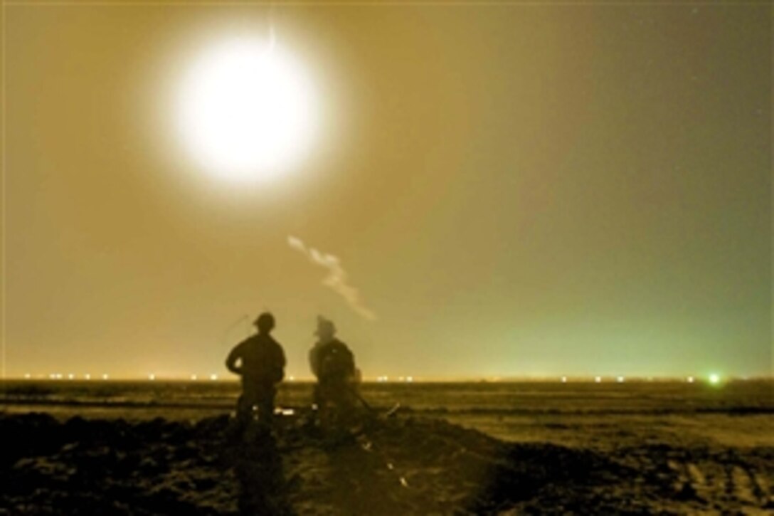 U.S. Army Sgt. Will Daniels and Pfc. Justin Dreyer scan the horizon for possible criminals using night vision goggles and a thermal imaging rangefinder the evening of Nov. 4, 2007. The pair went on a mission with the Romanian army's 341st Infantry Battalion stationed at Contingency Operating Base Adder, near Nasiriyah, Iraq. Daniels and Dreyer are forward observers in the Long Knife Brigade's combat observation and lasing team.