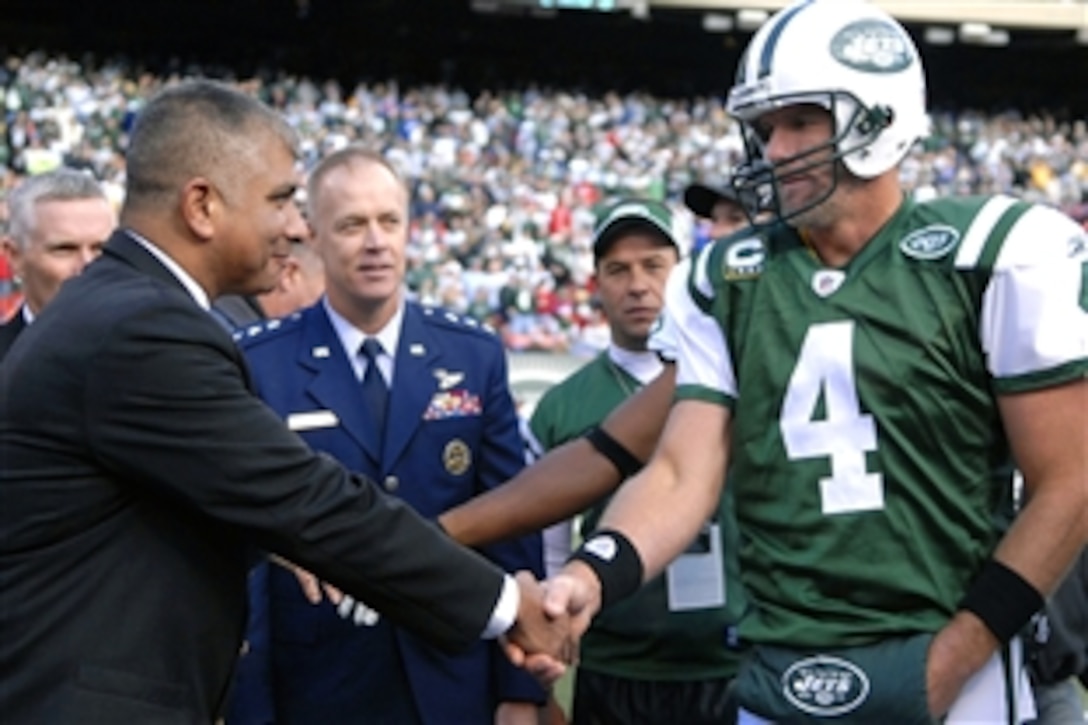 Master Chief Petty Officer of the Navy Joe R. Campa Jr. meets Brett Favre from the New York Jets during the coin toss on the field at the Meadowlands, East Rutherford, N.J., Nov. 9, 2008. The New York Jets took on the St. Louis Rams on Military Appreciation Day.