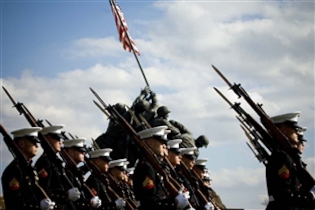 U.S. Marines march past the Marine Corps War Memorial during a wreath laying ceremony in honor of the 233rd Marine Corps birthday, Washington, D.C., Nov. 10, 2008. The sculpture of five Marines and a Navy Corpsman raising an American flag atop Mount Siribachi commemorates the 6,800 servicemembers who died capturing the Japanese island of Iwo Jima during World War II.