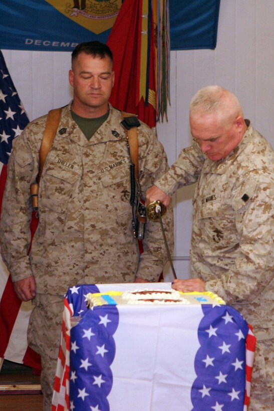 Col. Patrick J. Malay, commanding officer, Regimental Combat Team 5, cuts the first piece of cake during the regiment's Marine Corps birthday ceremony while Sgt. Maj. Robert D. Thielen, the regiment's sergeant major, observes at Camp Ripper, Iraq, Nov. 10.  The Marines of RCT-5, which is the most decorated regiment in the Marine Corps, have been in Iraq since the beginning of the year and took time to celebrate the Marine Corps 233rd birthday.::r::::n::