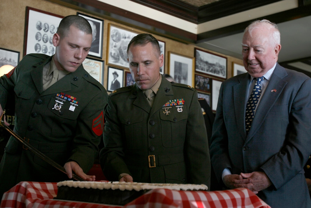 Cpl. Jeremy Andrews, left, and Maj. Tom Jasper, both with the 22nd Marine Expeditionary Unit, stand next to a retired Marine as Andrews cuts a piece of cake during a small Marine Corps Birthday  ceremony held Nov. 10, 2008, at P.J. Clarkes in New York. The Marines had just attended a concert by the Quantico Marine Corps Band in Battery Park. The Marines were in New York to support Veterans Day and the reopening of the Intrepid Sea, Air and Space Museum after a two-year renovation project. ::r::::n::(Official U.S. Marine Corps photo by Lance Cpl. Brian Lewis.)::r::::n::