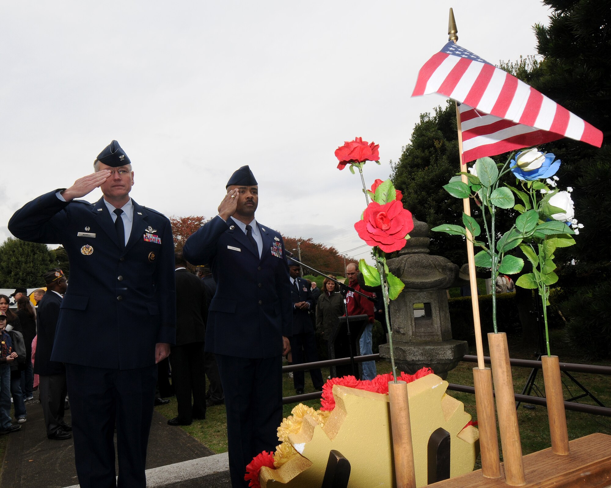 YOKOTA AIR BASE, Japan -- Col. Jeff Newell (left), 374th Airlift Wing commander, and Chief Master Sgt. Linus Jordan, 374th AW command chief master sergeant, honor U.S. veterans Nov. 11 during the Veterans Day ceremony sponsored by the Yokota chapter of the Veterans of Foreign Wars.  This ceremony was one of two conducted here.  The other was sponsored by American Legion Post 2222.  (U.S. Air Force photo by Senior Airman Laszlo Babocsi)