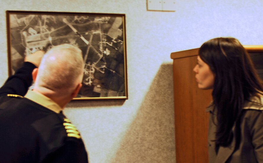 Ms. Kelly Akens on her visit to her grandfather's WWII base at Molesworth, England observes as JIOCEUR Deputy Commander, Navy Captain Henry J. "Harry" Babin points out features of the base as it looked during 1945 when her grandfather, Sergeant Thomas I. Akens flew from the main runway on this base in the B-17 "Sweet Rose O'Grady" under the command of 1st Lieutenant George Sabine.  Ms. Akens is the first grandchild of a 303rd Bomb Group veteran to visit the base near Huntingdon, Cambridgeshire, England. (U.S. Air Force photo by Staff Sgt. Janaine Paige)