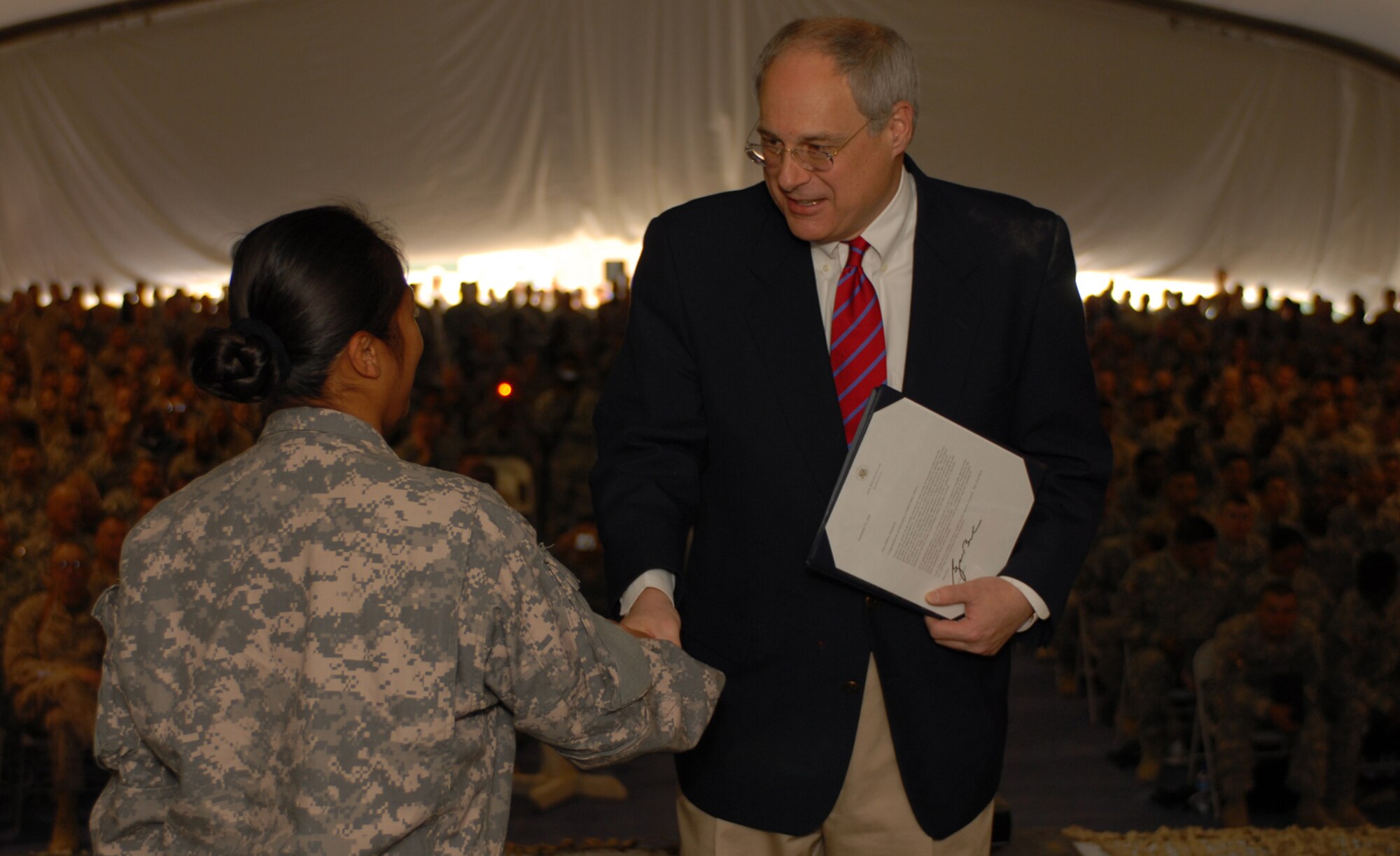 The Ambassador of the Islamic Republic of Afghanistan, Bill Wood, gives certificates of naturalization to 77 service members at Bagram Air Field, during a ceremony Nov. 11. (U.S. Army photo by Spc. Scott Davis/Released)