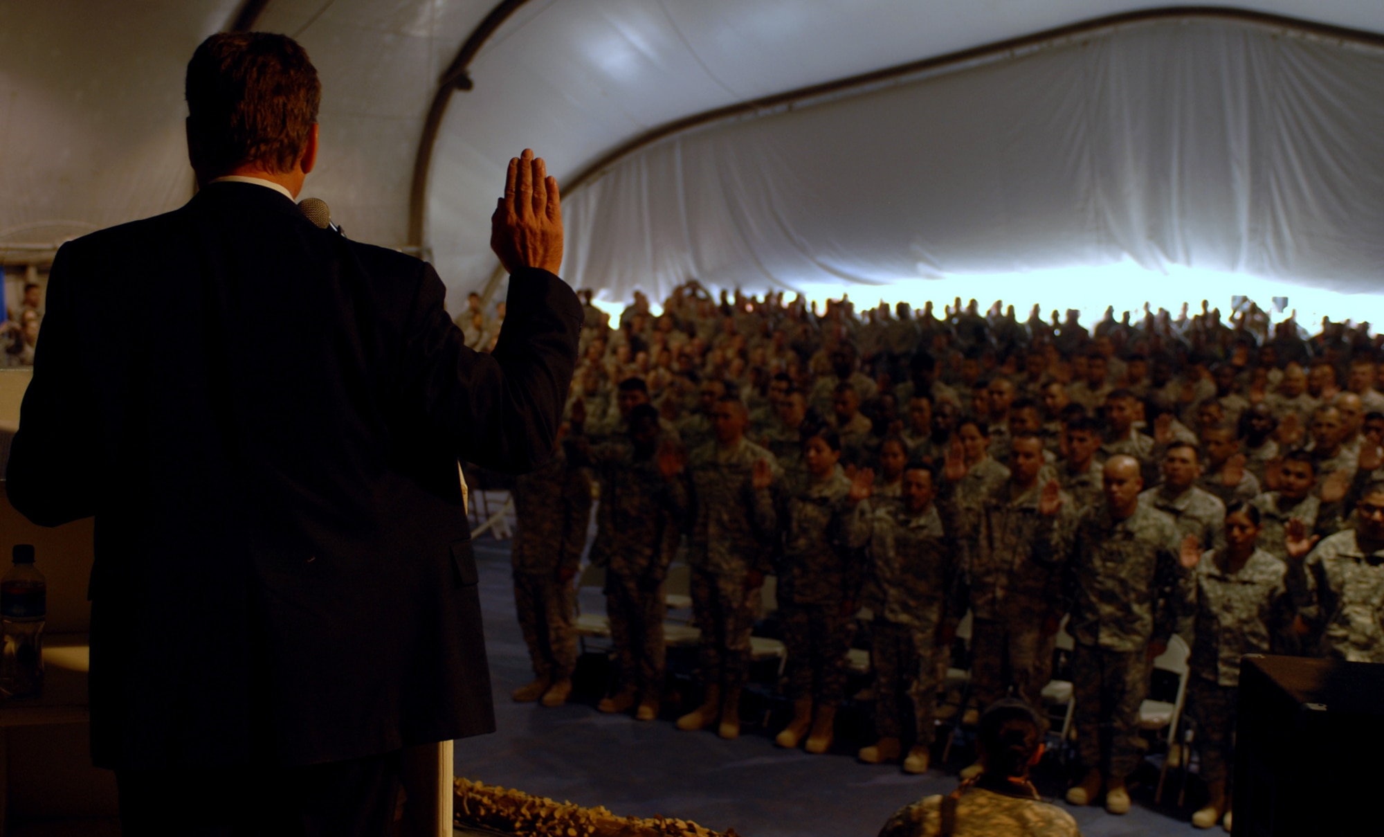 Robert Looney, district director form the United States’ Citizenship and Immigration Services, Bangkok District Office, administers the oath of naturalization to 77 service members at Bagram Air Field, Afghanistan Nov. 11. (U.S. Army photo by Spc. Scott Davis/Released)