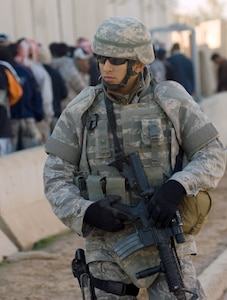 Airman 1st Class Israel Garza provides security near a checkpoint at Joint Base Balad, Iraq, Nov. 11. He was named the 332nd Air Expeditionary Wing's Tuskegee Airman of the Week for his actions during a security incident and protecting Iraqi officials and other distinguished visitors during a recent Iraqi-Based Industrial Zone ceremony on base. Garza, a security forces apprentice with the 532nd Expeditionary Security Forces Squadron, is deployed from Lackland Air Force Base, Texas. (U.S. Air Force photo/Tech. Sgt. Erik Gudmundson)